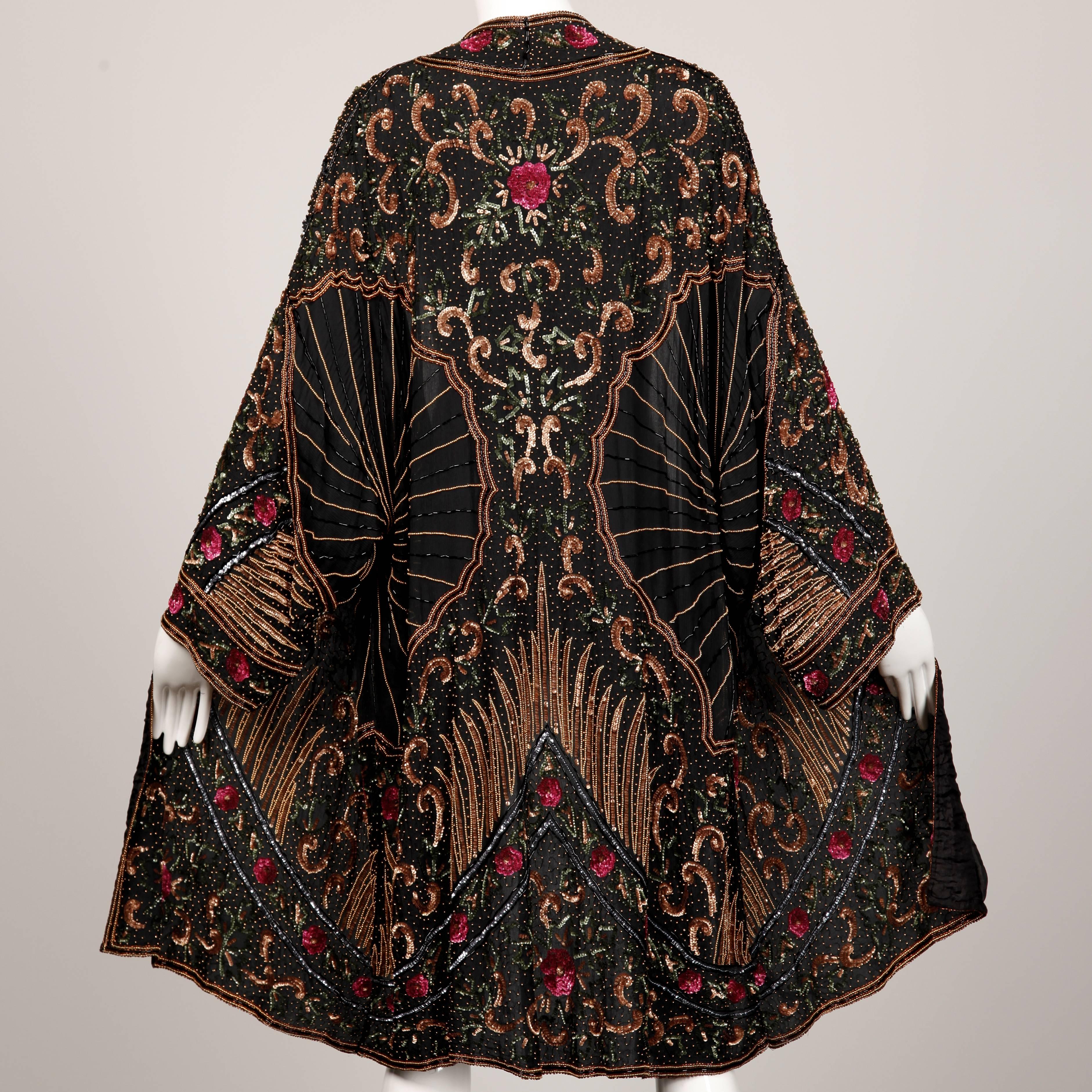 Elaborately beaded silk duster jacket by Judith Ann with an oversized fit. Stunning 1920s-inspired design. Fully lined in silk. No closure/ hangs open. The marked size is large, but it should fit sizes XS-XL due to the oversized fit. The bust, waist