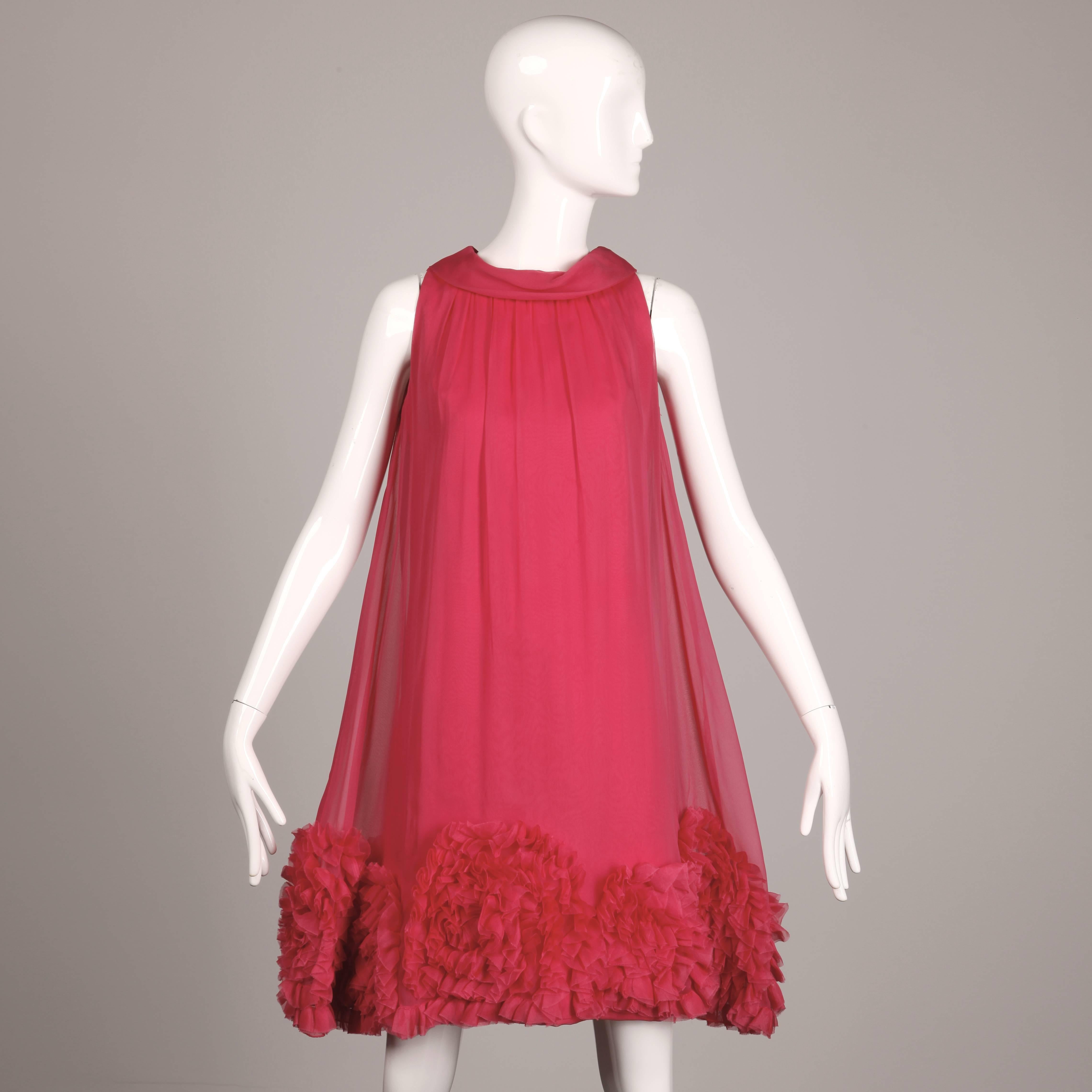 Classic 1960s silhouette with true A-line trapeze shape! Pink chiffon with a gathered ruffled hemline and sleeveless sleeves. Fully lined with rear zip closure. This dress fits like a modern size small-medium. The bust measures 36