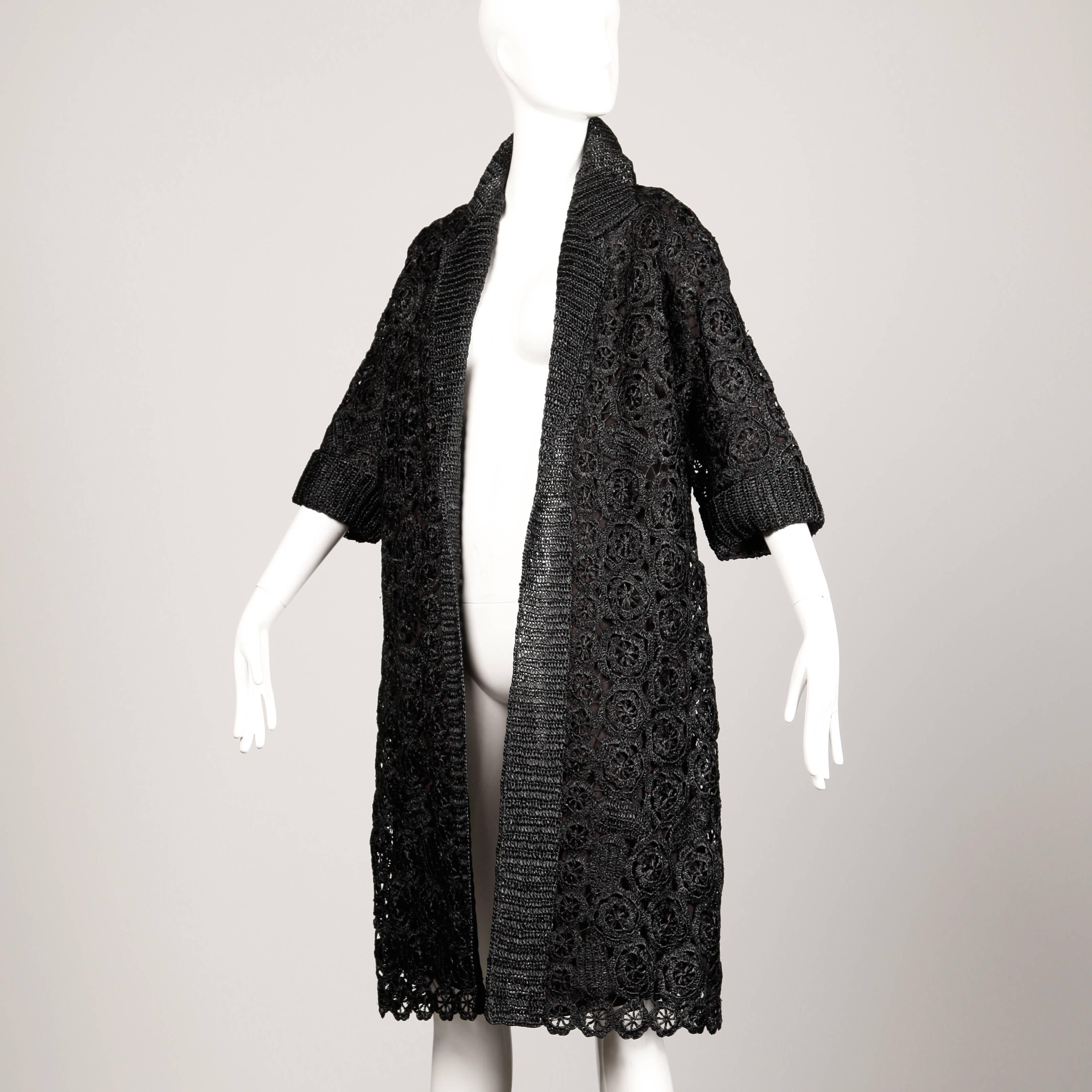 Incredible 1960s vintage black raffia coat with a scalloped lace edge. Fully lined with no closure (hangs open. Made in Italy. The marked size is a vintage Italian 48. The coat fits like a modern size small-large on account of its free shape. The