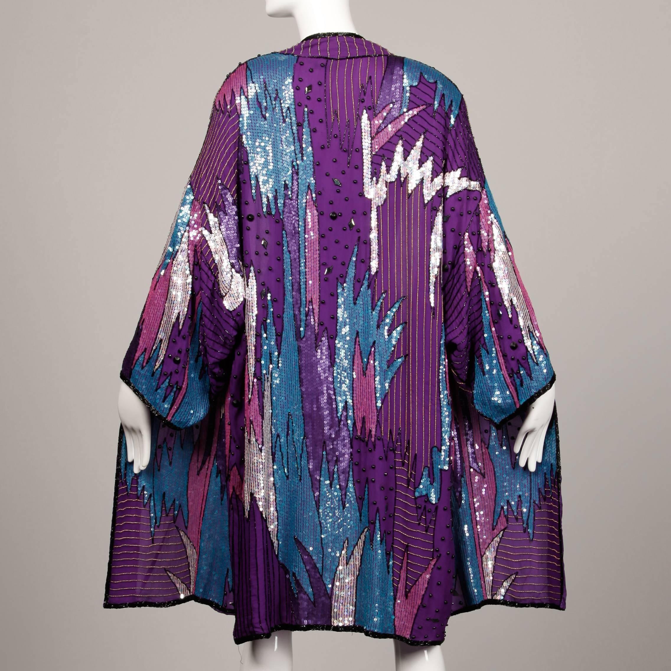 Elaborately beaded silk duster jacket by Judith Ann with an oversized fit. Stunning vibrant design. Fully lined in silk. No closure/ hangs open. The marked size is medium, but it should fit sizes XS-XL due to the oversized fit. The bust, waist and