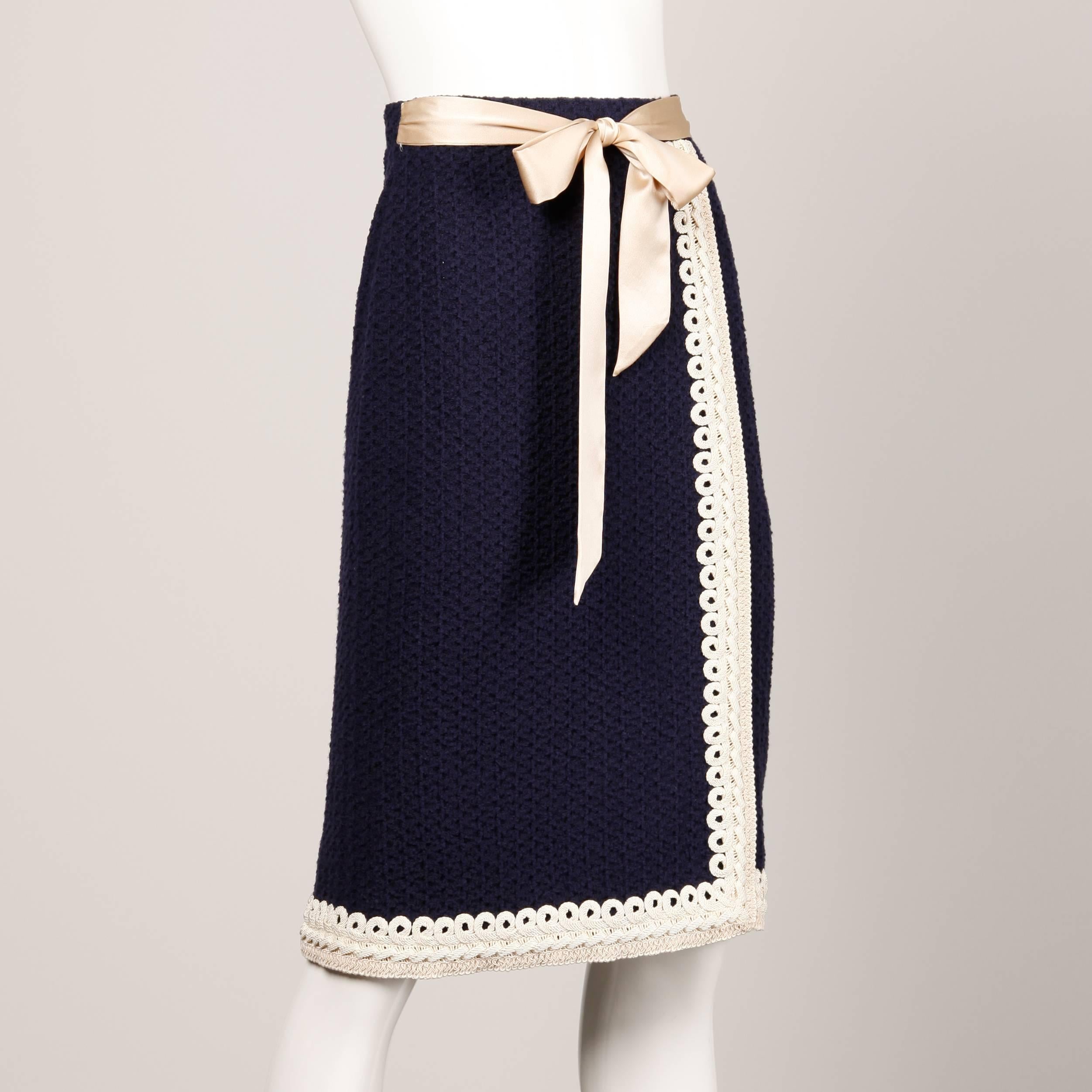 Stunning vintage navy blue wool knit skirt with ivory cord trim by Adolfo. Front silk satin bow detail. Elastic waistband. Fabric has some stretch. There is no marked size but the skirt will fit a modern US XS-S (Size 6 max). The waist measures