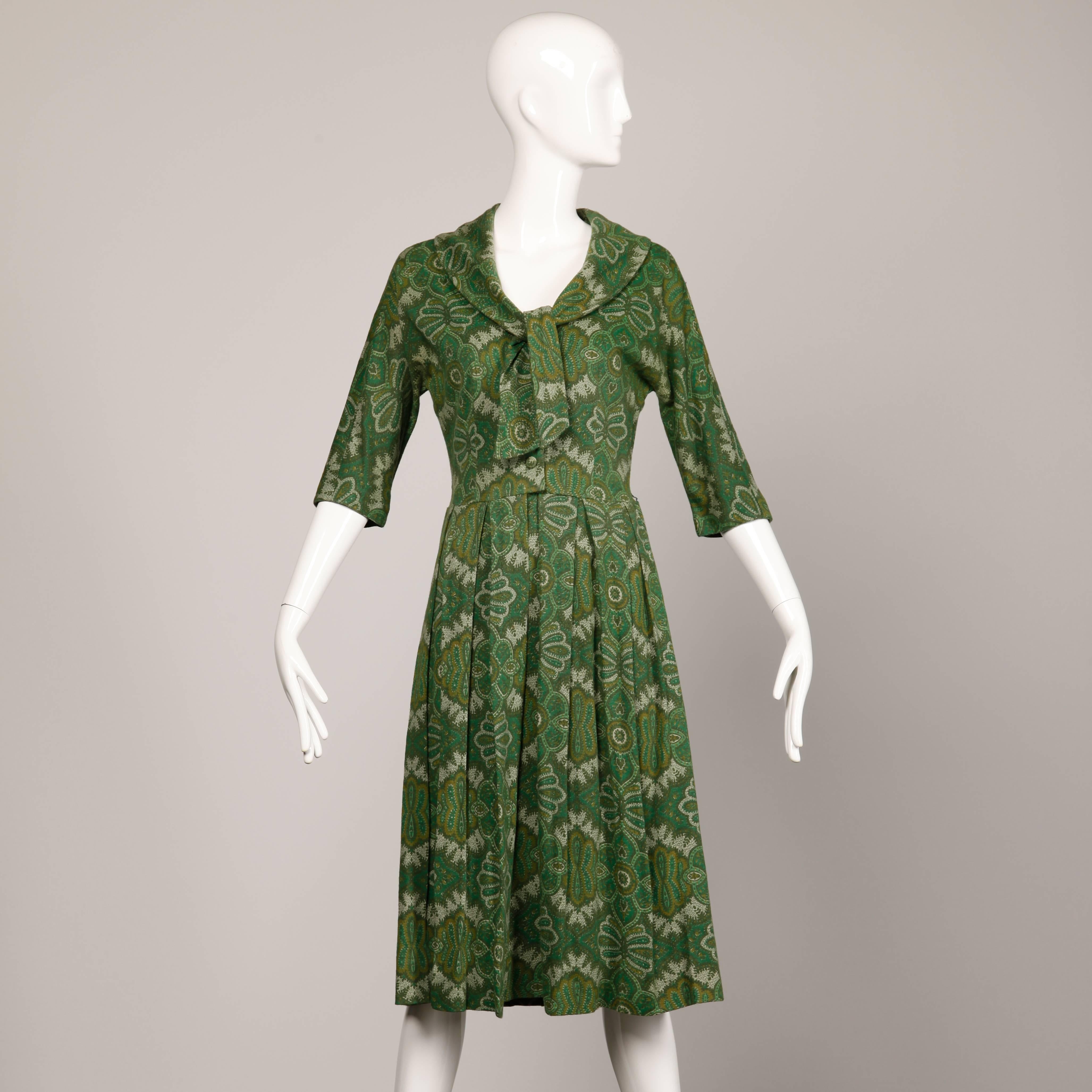 Vintage 1950s green paisley wool day dress with an ascot tie. Unlined with front button and snap closure. Fits like a modern size small. The bust measures 34