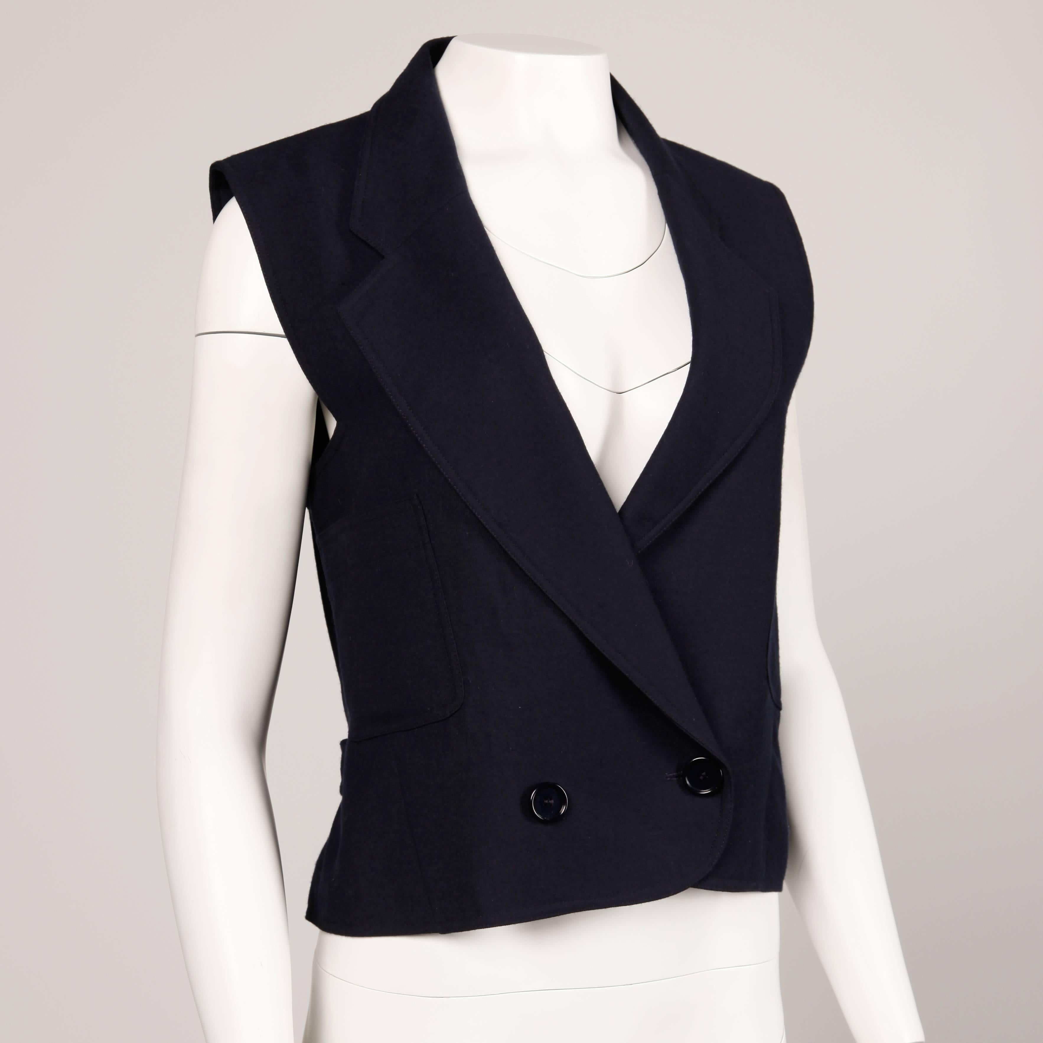 Beautifully done navy blue wool vest by Bernard Perris with back buckle detail. Fully lined. Fits like a modern size small-medium. The bust measures 38", waist 34", and total length 22". Excellent condition with no noted flaws.