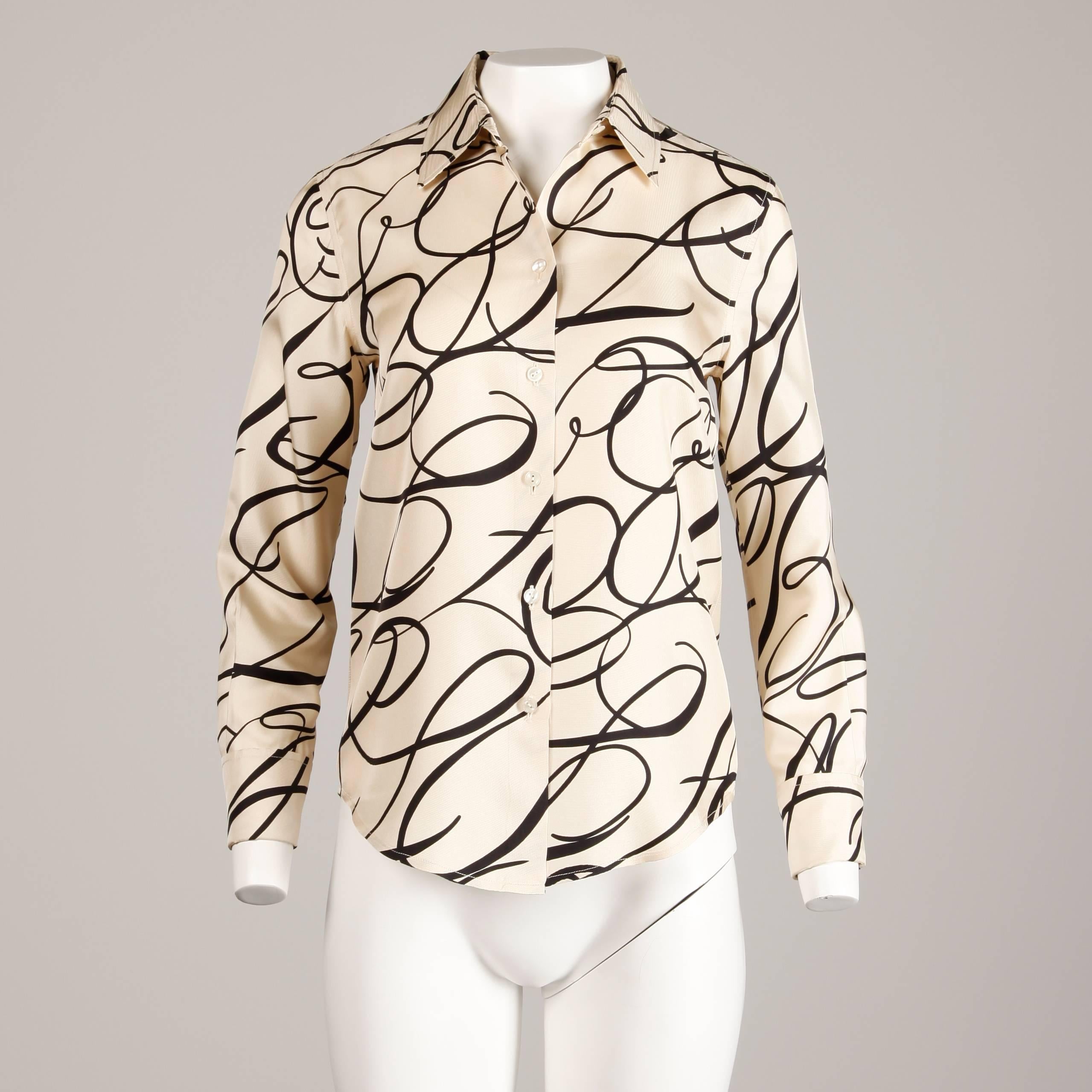 Gorgeous vintage silk blouse with a black scroll print attributed to Bill Blass (label is missing). Button up front and fold over sleeves that require cuff links (not included). Unlined. This blouse fits like a modern size small. The bust measures