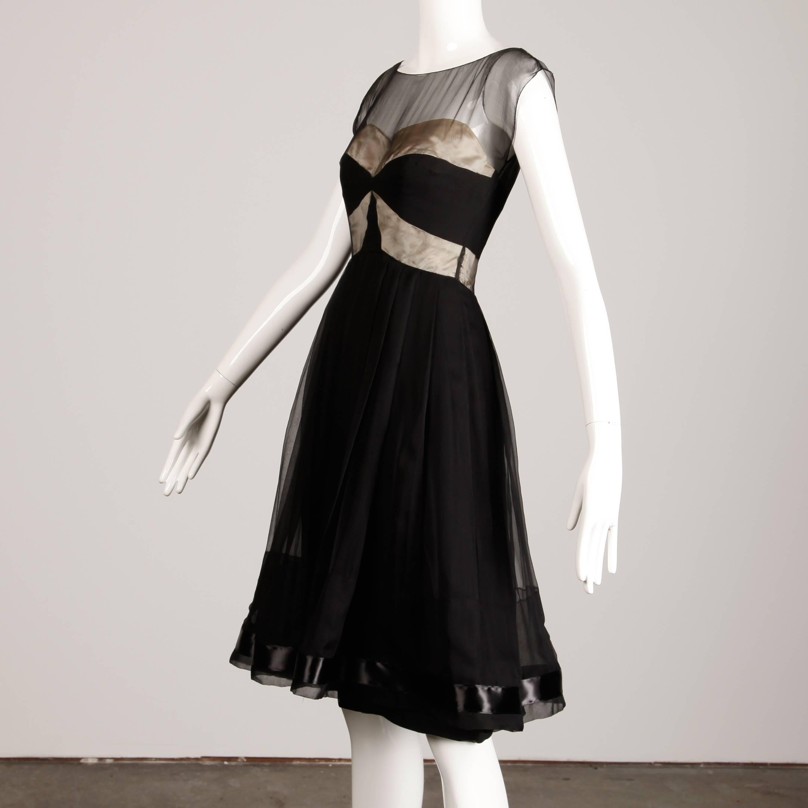 Stunning vintage early 1950s cocktail dress in black and nude silk satin and silk chiffon. Full skirt with silk lining and boned bodice. Gorgeous construction. Rear metal zip and hook closure. Fits like a modern size XS-S. The bust measures 33