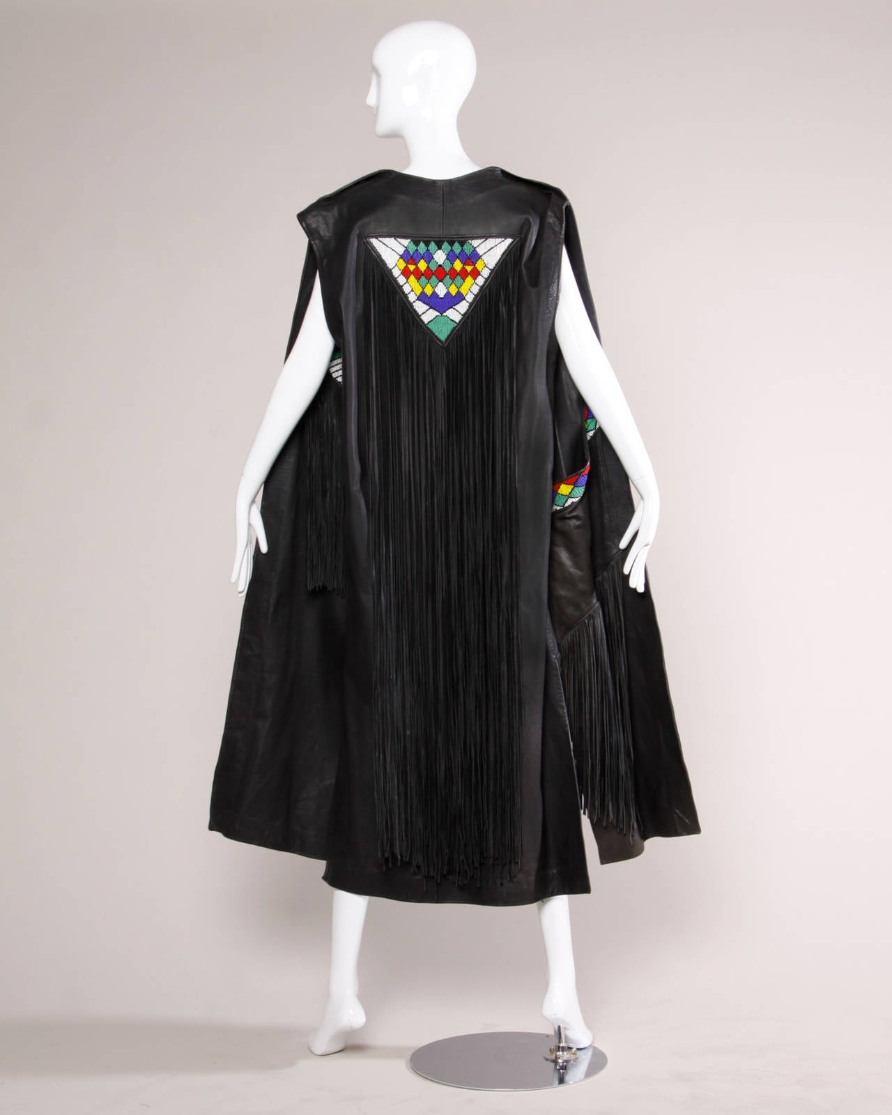 Incredible hand made vintage leather maxi vest with hand beading and long fringe trim. Thick, heavy black leather and colorful seed beads.

Details:

Unlined
Arm Slits
Estimated Size: S-L
Color: Black/ White/ Blue/ Green
Fabric: