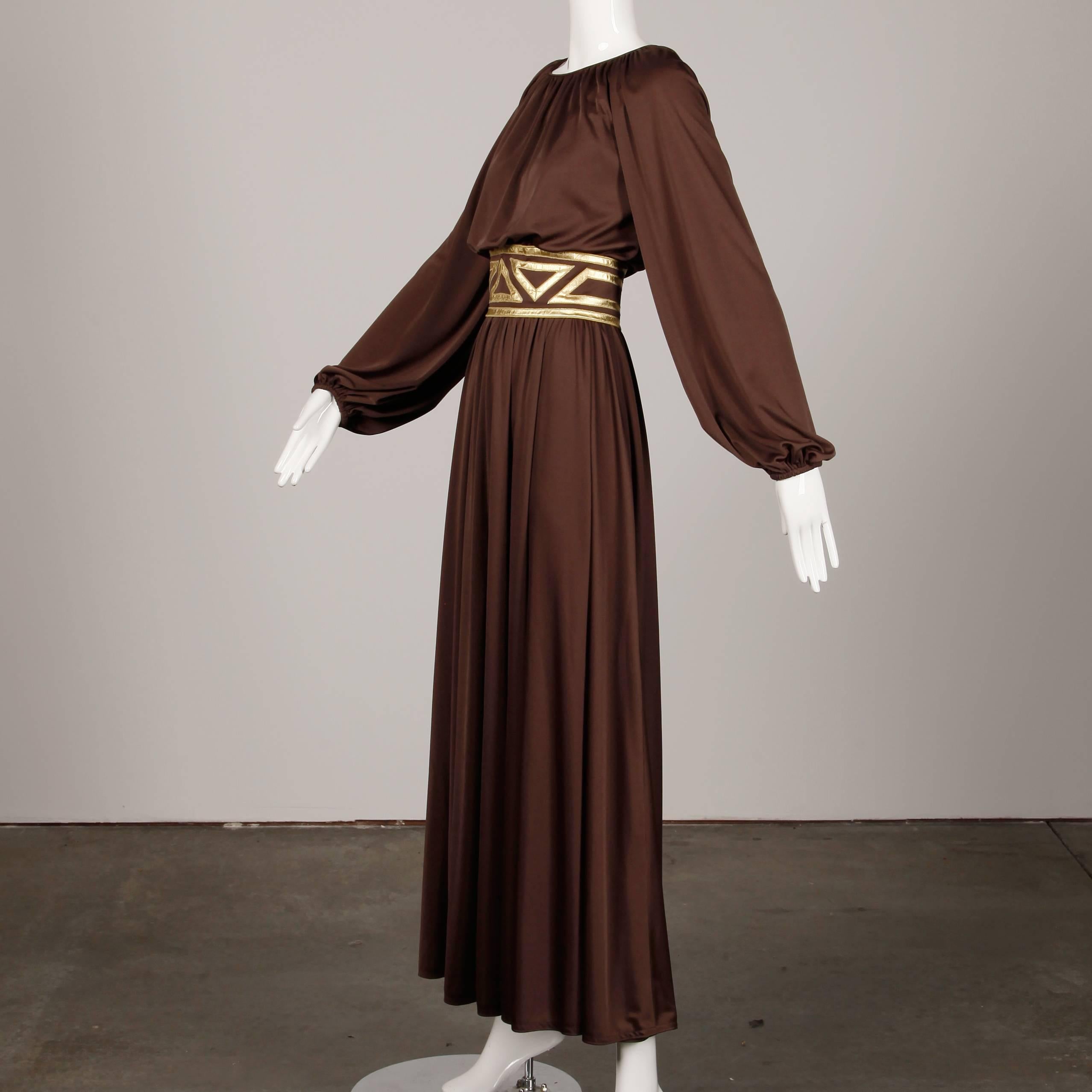 Grecian-inspired vintage 1970s chocolate brown jersey knit maxi dress with metallic gold waistband by Rizkallah for Don Friese. Partially lined with rear zip, hook, snap and button closure. Fits like a modern size small-medium. Measurement for bust
