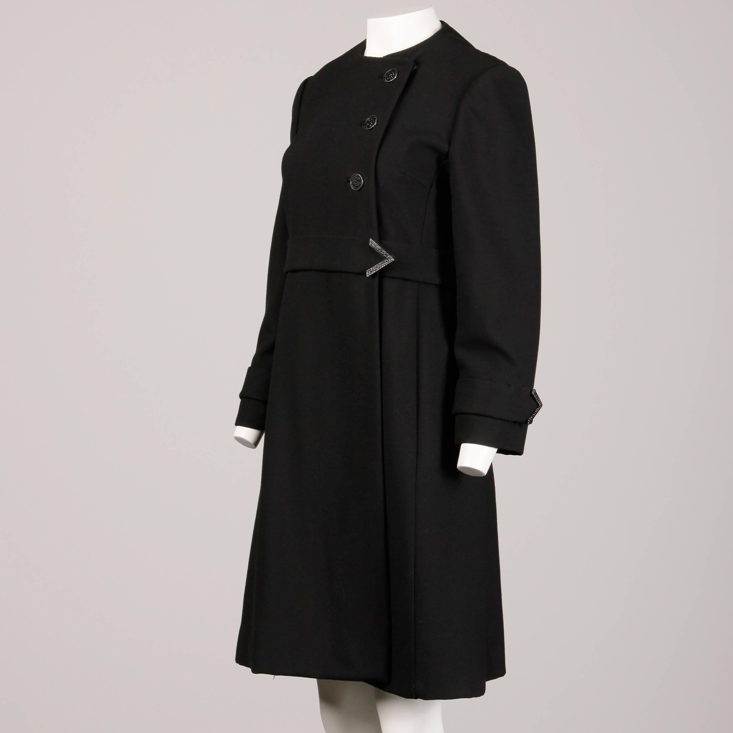 Vintage 1960s black wool coat by Youthcraft with asymmetric closure. Fully lined with asymmetric front button and snap closure. Front hidden pockets. Structured shoulder pads sewn in underneath the lining. Fits like a modern size small-medium. The