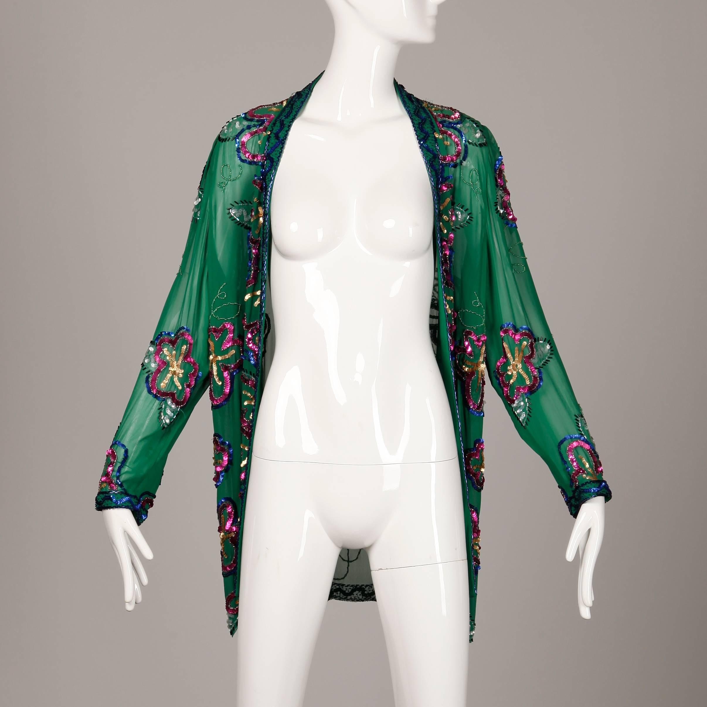 Shimmery 1980s sheer green silk jacket by Fabrice with colorful sequin and beadwork. Unlined, hangs open in the front. 100% silk. The marked size is an 8, and the jacket fits like a size small-medium. The bust measures 44