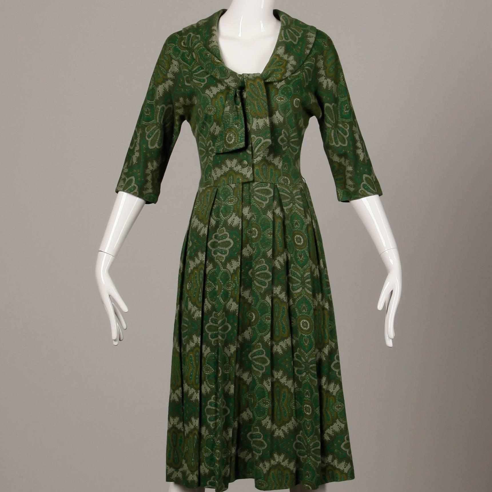 Vintage 1950s Jerry Gilden green paisley wool day dress with an ascot bow tie, 3/4 length sleeves, and pleated skirt. Unlined with front button, snap, hook and tie closure. Fits like a modern size small. The bust measures 36", waist