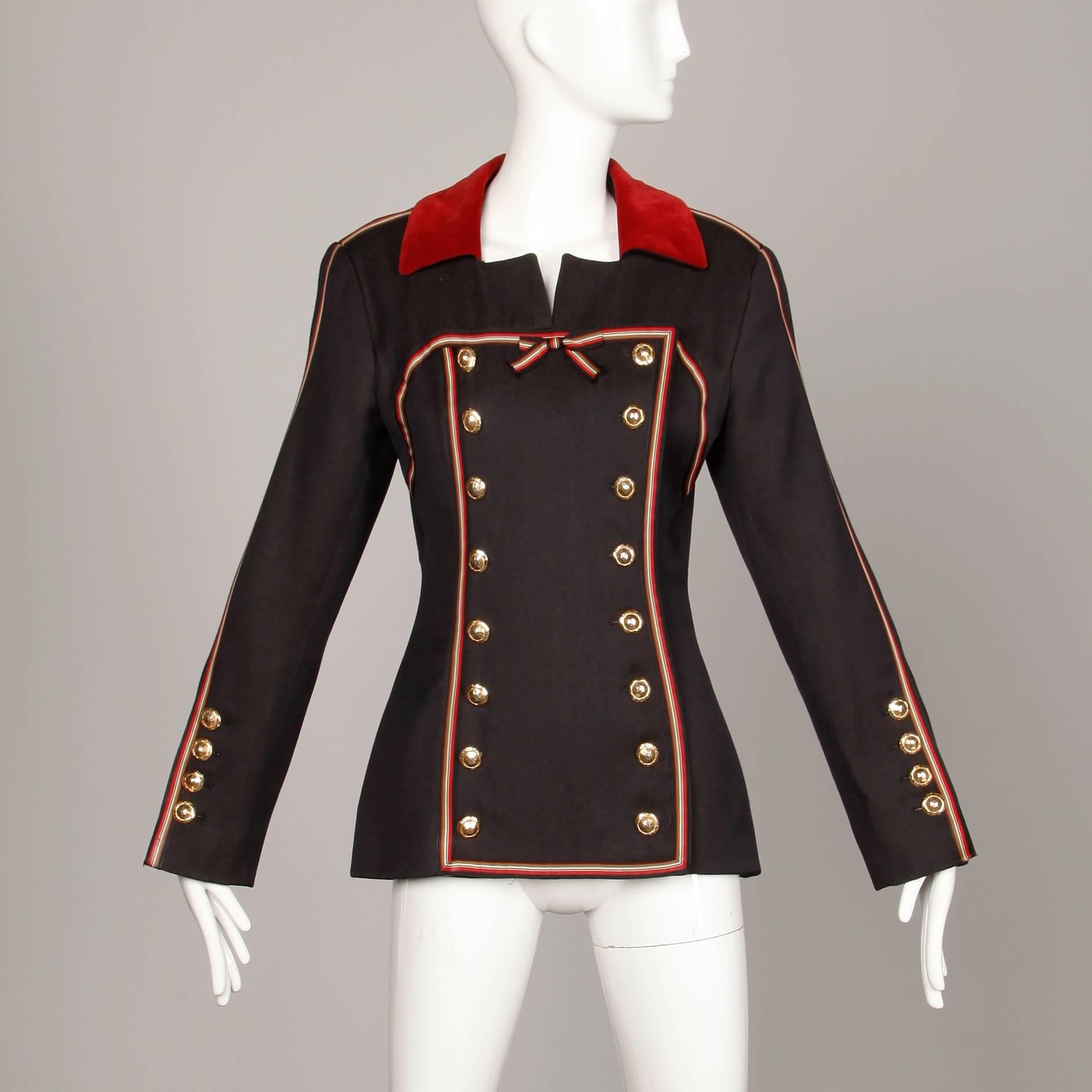 Incredible vintage Gemma Kahng! Military-inspired double breasted buttons, red velvet trim and striped ribbon detail. Fully lined with front button and snap closure. Faux rear pockets. Structured shoulder pads are sewn in underneath the lining. The