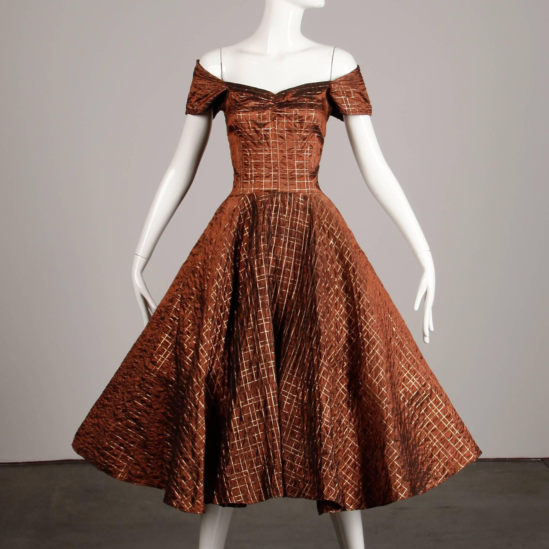 Chic 1950s vintage dress in a brown/ copper taffeta with metallic plaid embroidery and full circle sweep. Unlined with rear metal zip closure. Fits like a modern XS-S. The bust measures 32