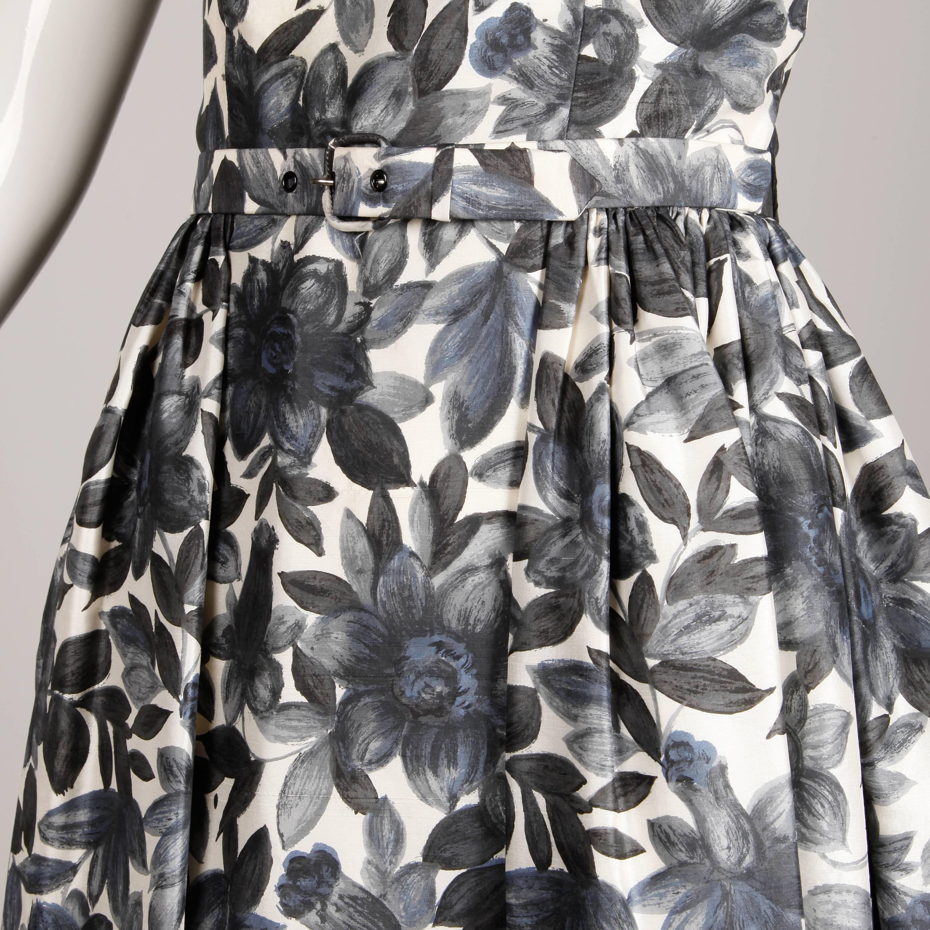 Beautiful vintage 1950s silk dress in a gray and blue watercolor floral print with matching belt. Fully lined with rear metal zip and hook closure. Fits like a modern size small. The bust measures 38