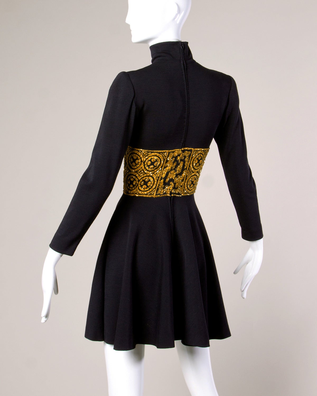 Pretty vintage black wool knit dress with an Asian-inspired gold beaded waistband, long sleeves, and high neck. 

Details:

Partially Lined
Rear Zip Closure
Small Structured Shoulder Pads
Marked Size: 4/ Small
Colors: Black/ Gold
Label: Bob