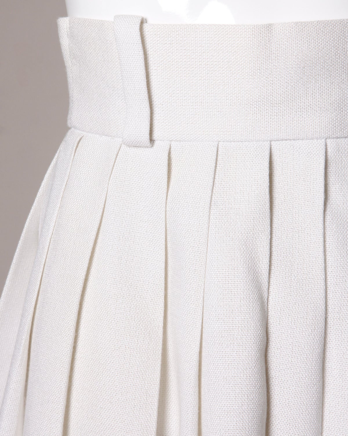 Sleek white linen pleated skirt with black ribbon trim by Anne Fogarty.

Details:

Unlined
Back Zipper and Hook Closure
Marked Size: 6
Estimated Size: XS
Color: Ivory/ Black
Fabric: Feels like Linen
Label: Anne