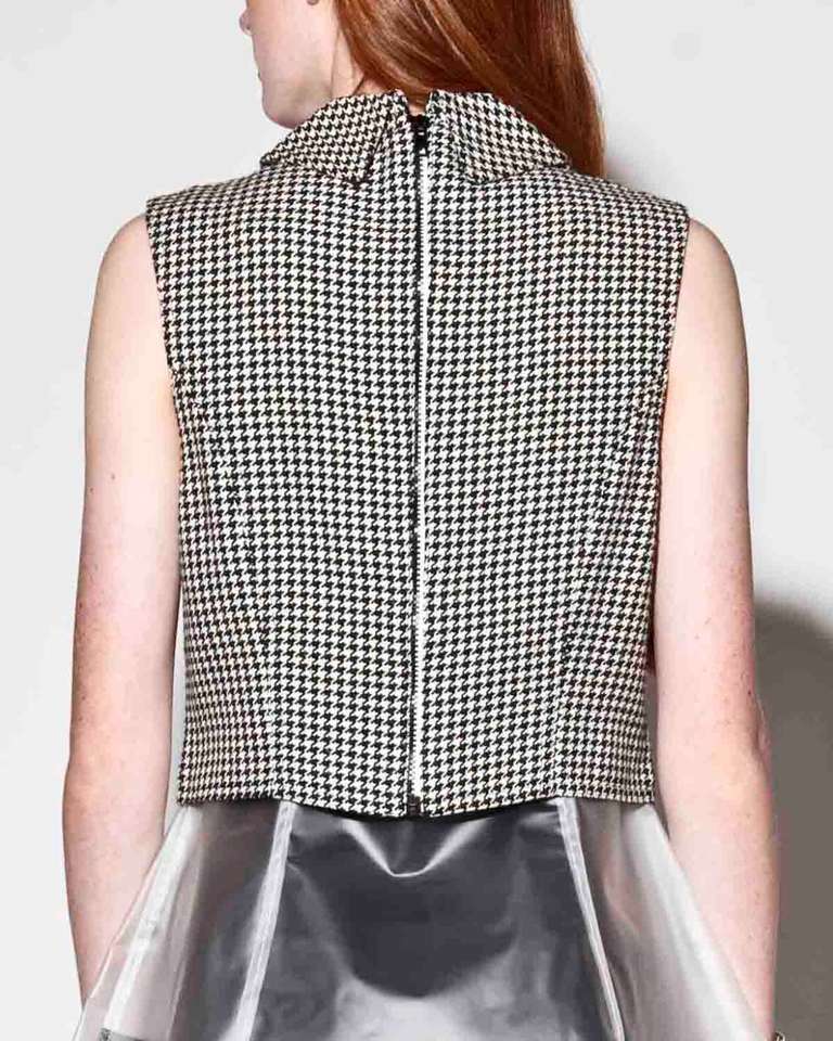 Sporty 1990s black and white houndstooth sleeveless jacket with a two-toned zip up front AND back! By Versace Jeans Couture.

Fully lined
Front and back zip closure
Front pockets
Circa: 1990s
Label: Versace Jeans Couture
Marked Size: