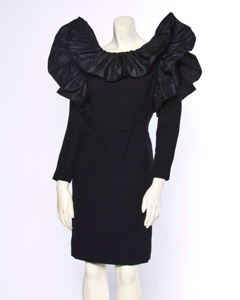 Avant garde wool sheath dress with dramatic ruffles around the neck and shoulders. Fully lined with rear zip and hook closure. By William Pearson.

MEASUREMENTS
Bust: 38