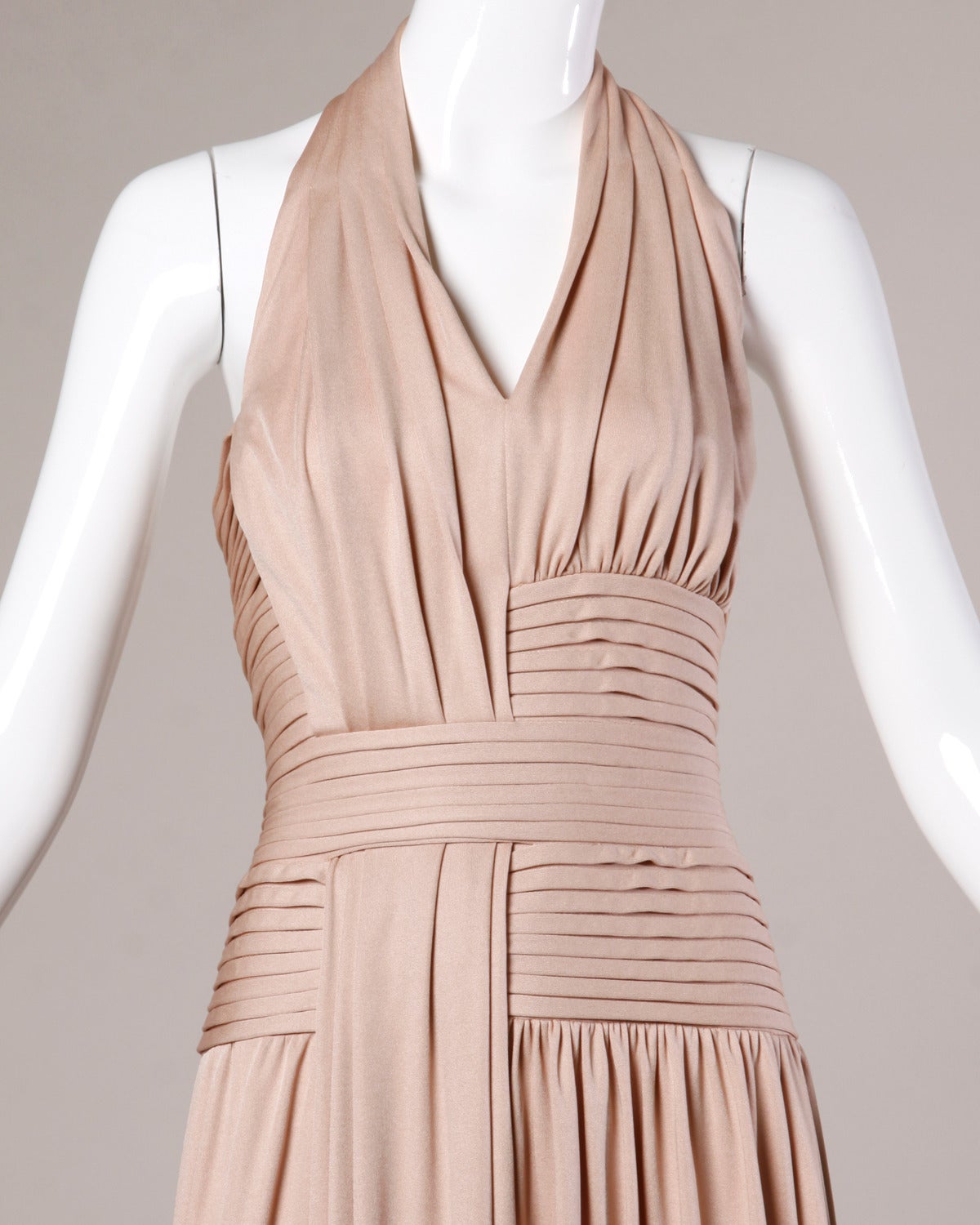 Unworn vintage nude silk jersey halter gown by Rizkallah for Don Friese. Amazing asymmetric construction and plunging neckline. This dress is so flattering on the body!

We originally received this with the original tags attached in unworn