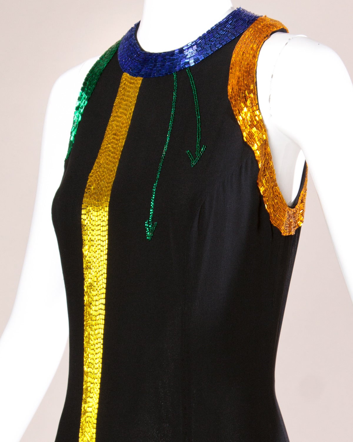 Vintage black silk gown by New York designer Fabrice with brightly colored abstract beadwork in yellow, green, red and blue. Back slit and sleeveless sleeves.

Details:

Fully Lined
Back Zip Closure
Marked Size: 6
Estimated Size: