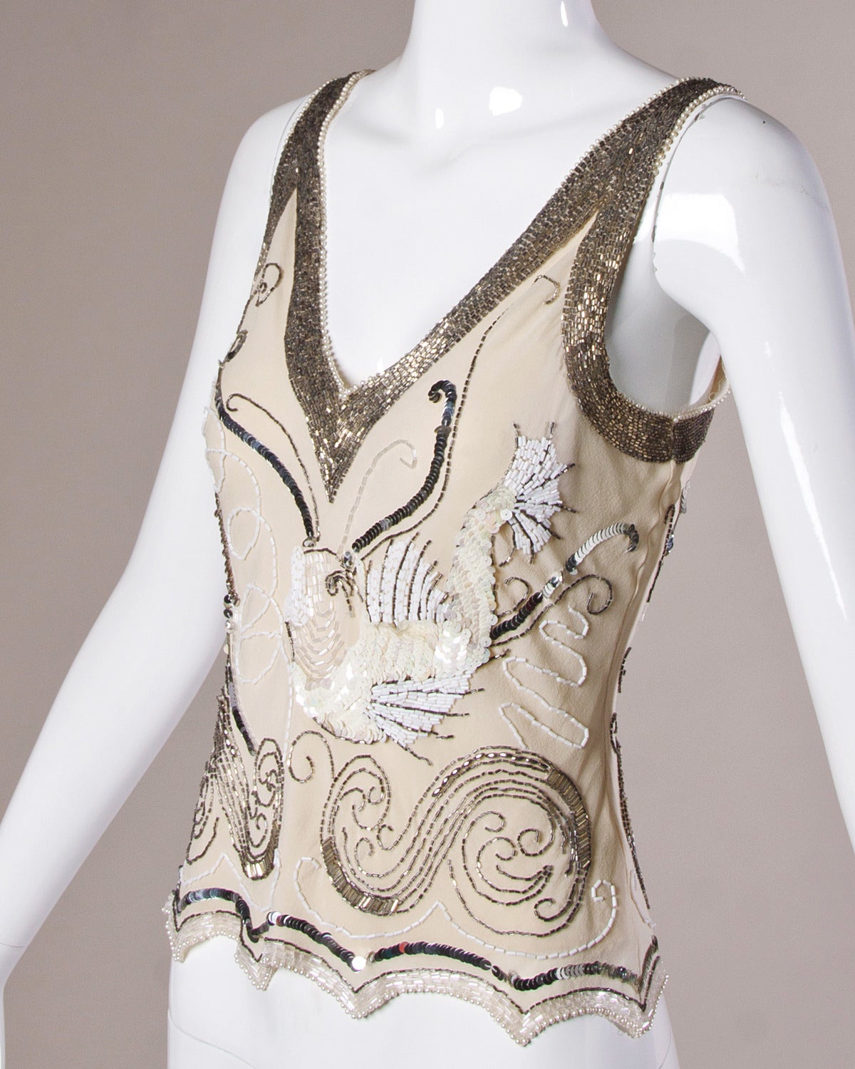 Gorgeous 1920's-inspired ivory silk sleeveless top with elaborate hand beading and sequin design by Fabrice.

Details:

Fully Lined
No Closure/ Fabric Contains Stretch
Marked Size: M
Estimated Size: Small-Medium
Color: Ivory/ Iridescent