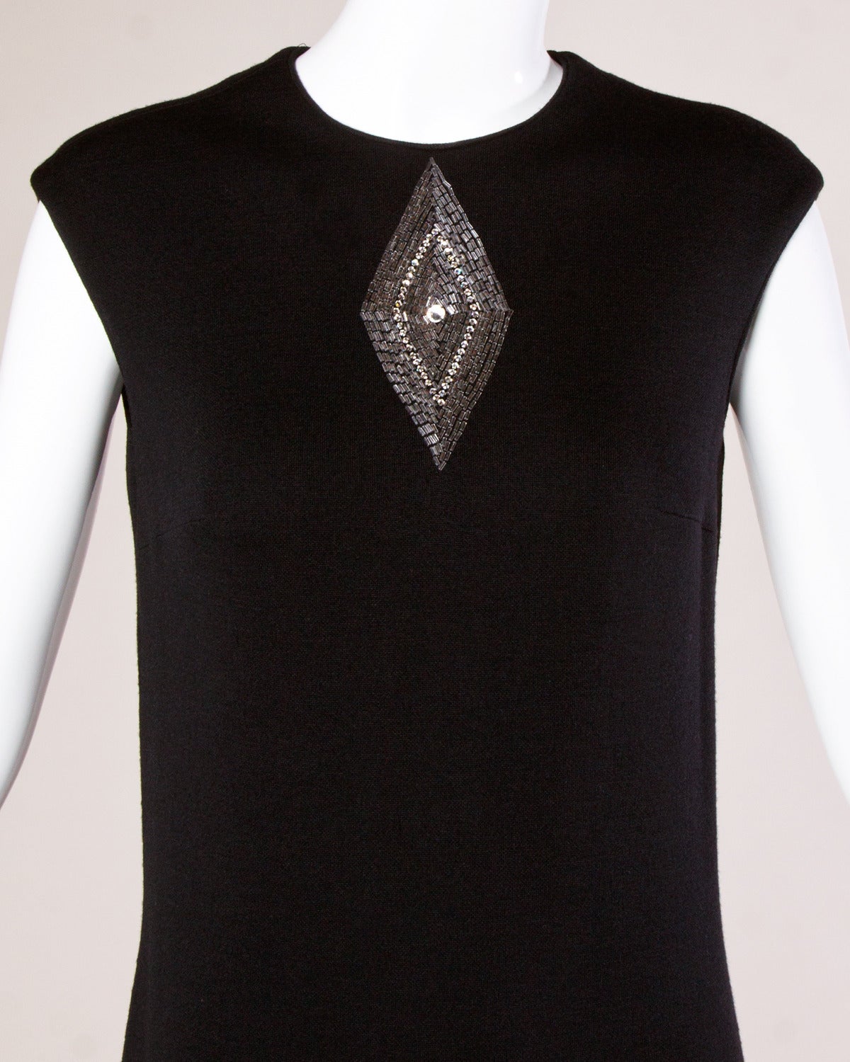 Mr. Blackwell black wool shift dress with mod beaded and rhinestone embellished diamond design. Bow detail at the back of the neck.

Details:

Fully Lined
Back Zip and Hook Closure
Marked Size: Not Marked
Estimated Size: Small
Color: Black/