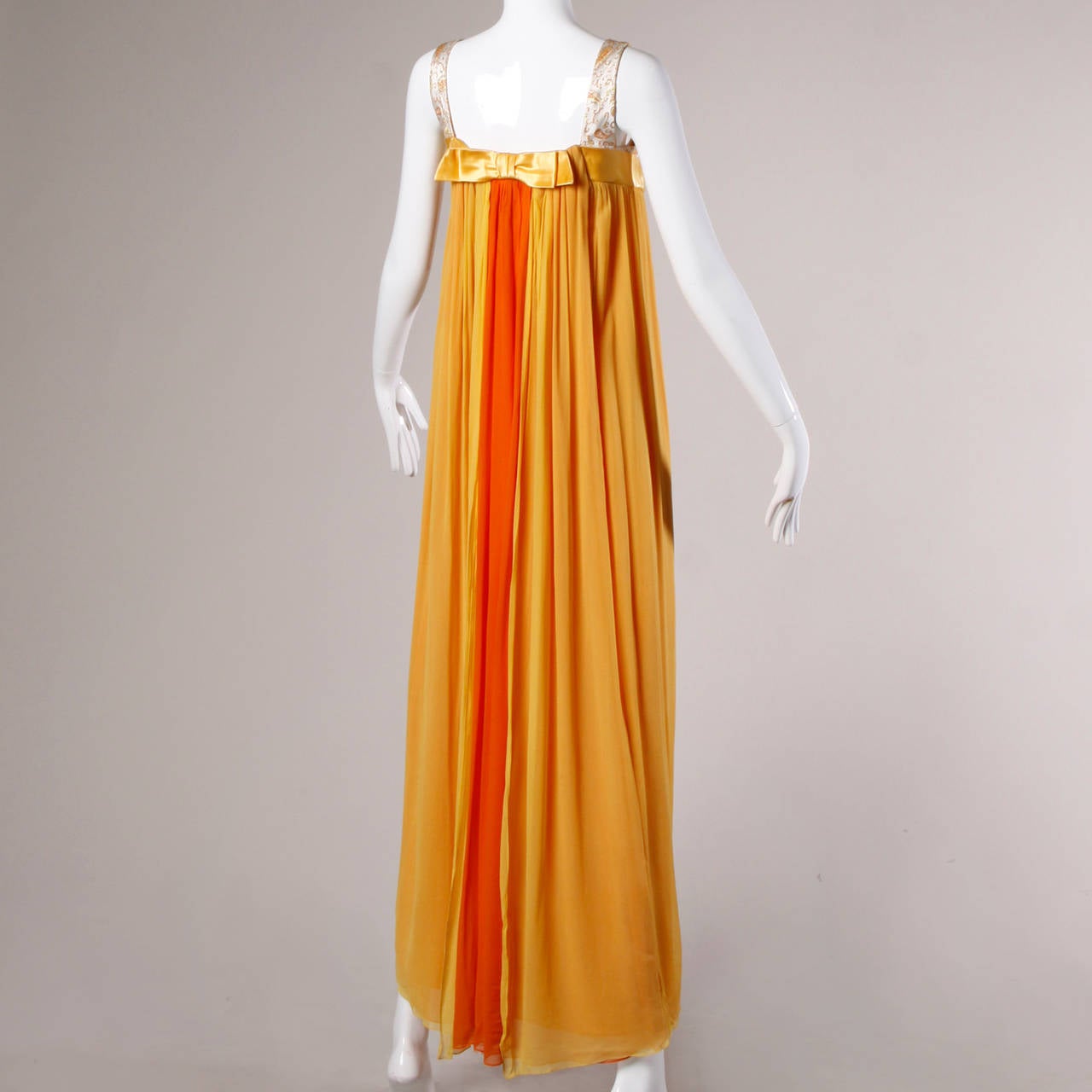 Vintage 1960s maxi dress in layers of citrus colored silk chiffon. Empire waist and back train.

Details:

Partially Lined
Back Metal Zip and Hook Closure
Marked Size: Not Marked
Estimated Size: Small
Color: Bright Orange/ Bright