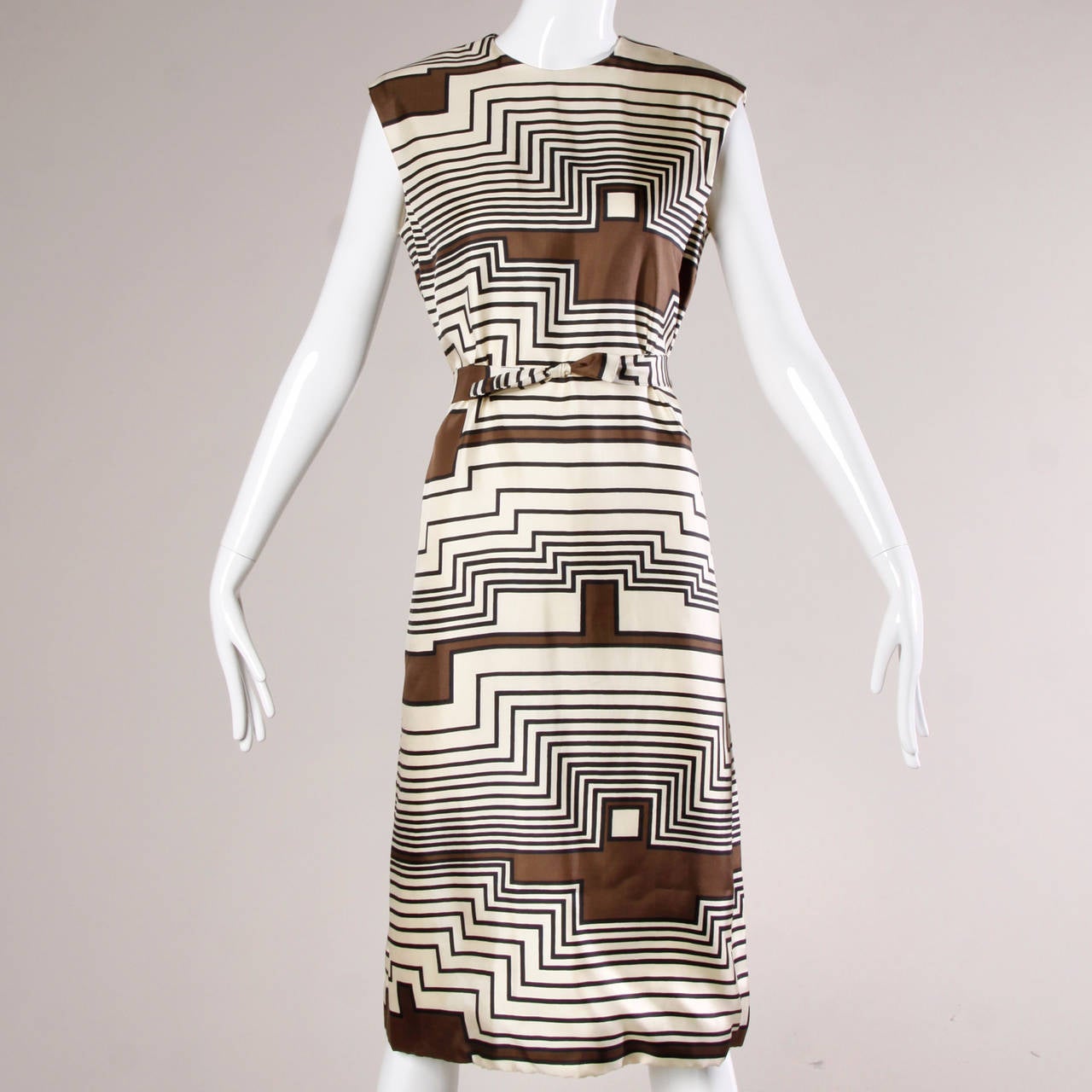 Gorgeous medium weight creamy silk shift dress with a graphic op art print by Adele Simpson for I. Magnin. The dress is unworn with the original price tags still attached! The dress comes with a matching scarf and sash. 

Details:

Fully lined