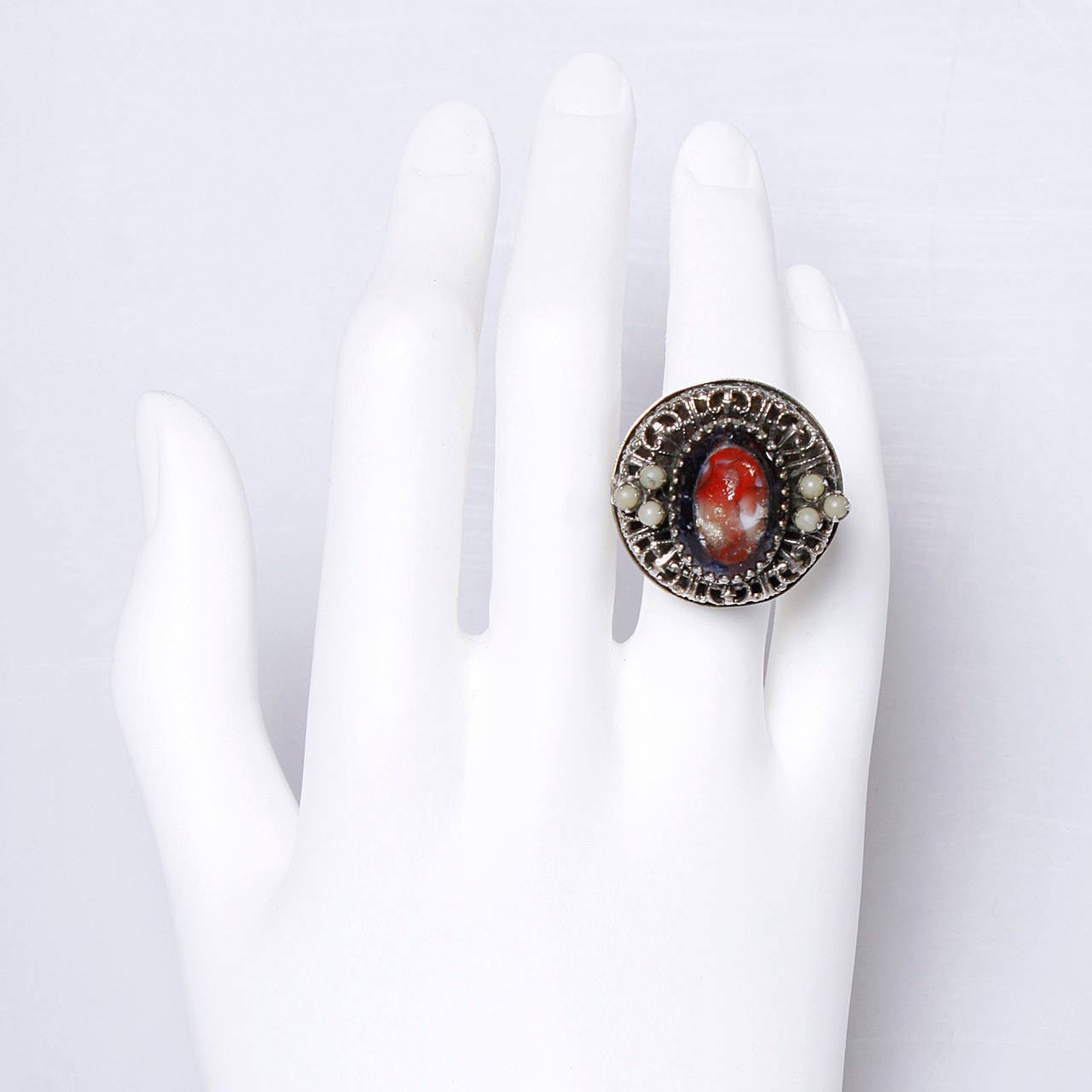 Large filligree cocktail ring by Elsa Schiaparelli. Signed on the back of the piece.

Details:

Closed Band
Hollow
Size: 9
Color: Gold Metallic/ Blood Red/ Black Iridescent/ Tan/ Light Gray/ Pale Yellow/ Silver
Signature: