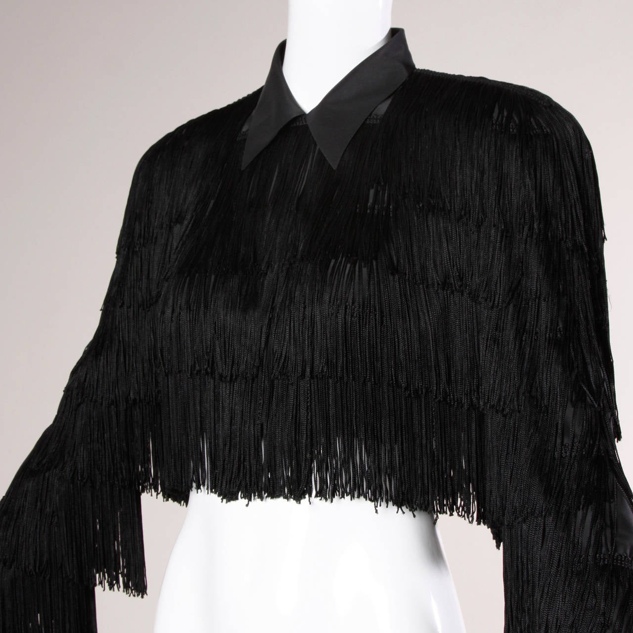 Vintage 1920s-inspired black fringe jacket by Norma Kamali. 

Details

Fully lined
Front Hook Closure
Circa: 1980s
Marked Size: 2
Estimated Size: S-M
Color: Black
Fabric: 100% Rayon
Label: Norma Kamali

Measurements

Bust: