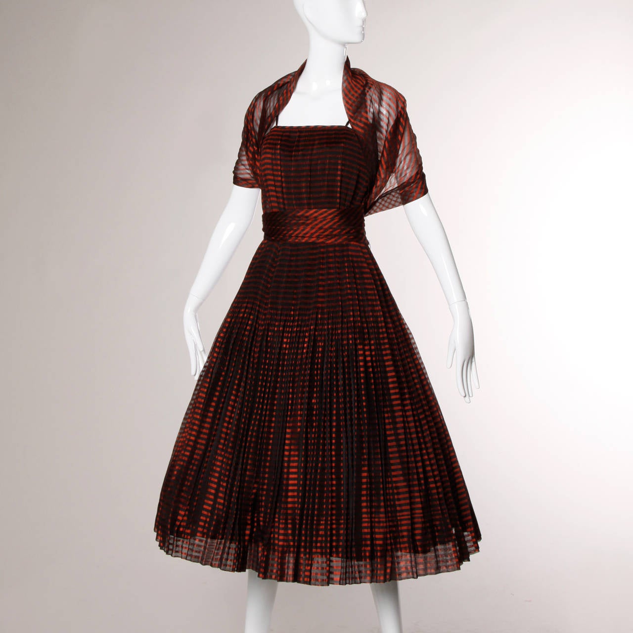 Phenomenal two-piece set from the 1940s featuring a wrap/ stole and a strapless dress with crystal pleats (so much fabric!). Sheer metallic red and black striped fabric on both pieces. The dress is fully lined and has side metal zip and hook