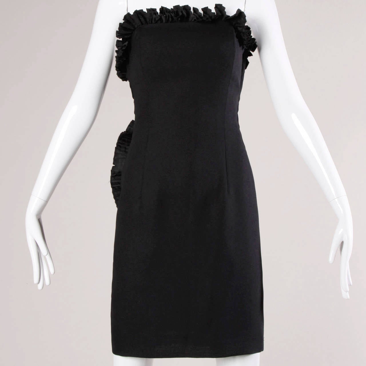 Unique strapless black cocktail dress by Victor Costa. Origami fan pleating and asymmetric back detail.

Details:

Fully Lined
Side Zip Closure
Marked Size: Not Marked
Estimated Size: Small
Color: Black
Fabric: Not Marked
Label: Victor