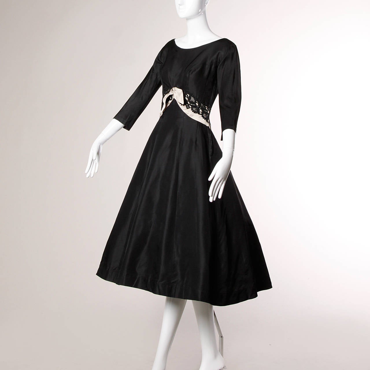 Pristine vintage cocktail dress by David Hart in black silk satin. Beige silk satin and lace waist detail and scooped open back. 

Details:

Fully Lined
Built In Crinoline
Side Metal Zip Closure
Marked Size: Not Marked
Estimated Size: