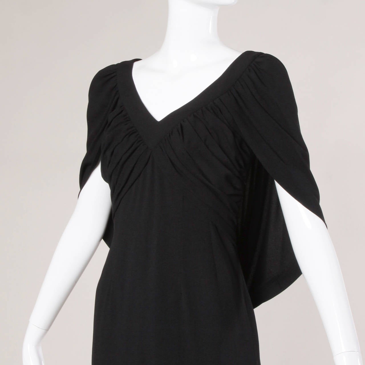 Vintage black crepe dress dress by couture designer Don Loper. Unique ruched empire waist with attached cocoon shaped cape attached.

Details:

Partially Lined
Back Metal Zip and Hook Closure
Marked Size: Not Marked
Estimated Size: