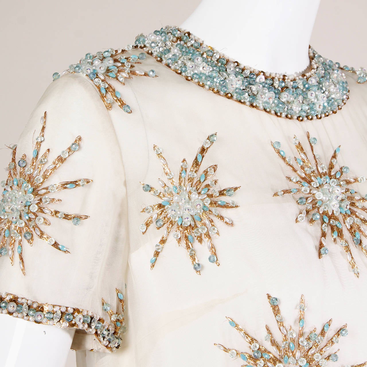 Extraordinary 1960s silk shift dress with starburst embellishments and the original tags still attached. Hand beadwork.

Details:

Fully Lined
Back Metal Zip and Hook Closure
Marked Size: 12
Estimated Size: S-M
Color: Ivory/ Gold Metallic/