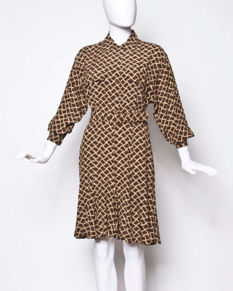 Vintage brown and tan geometric print dress by Norma Kamali Omo. This dress features a button up front, dolman sleeves and a matching belt. Unlined with front button closure.

It is a marked size 4 and will best fit a modern 2-4.