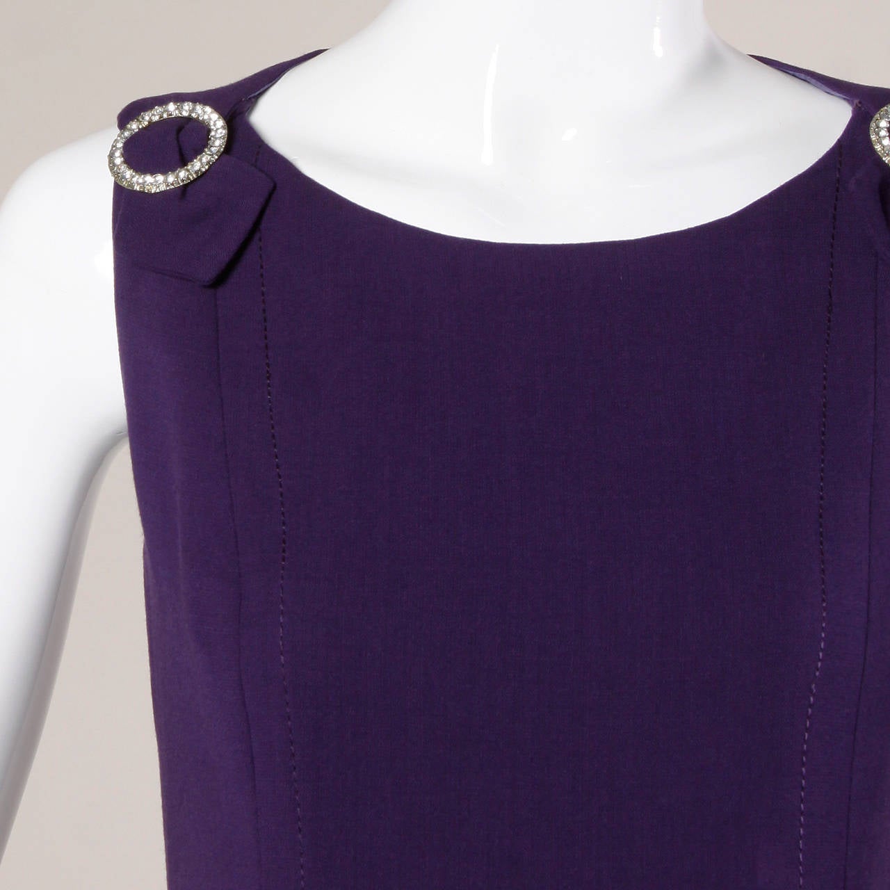 Absolutely stunning couture construction! Hand stitched wool 1960s vintage dress in deep purple wool with creamy purple silk lining and a car wash hem. Rhinestone detail at the shoulders. 

Unfortunately there is no designer label but the