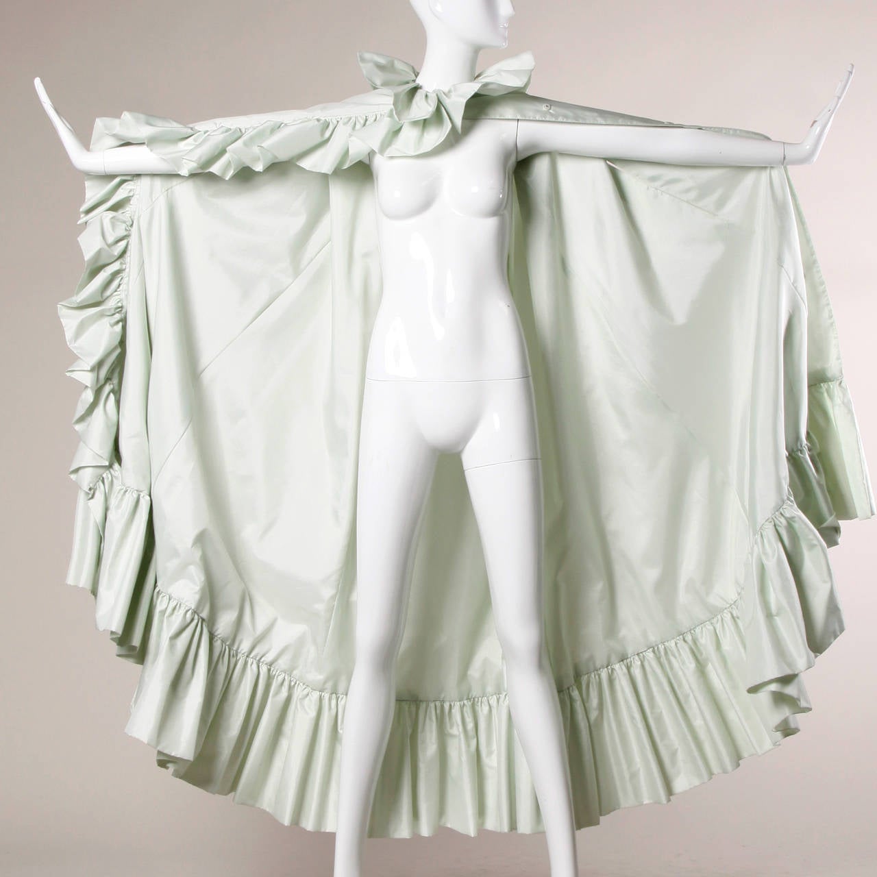 Pale mint green cape coat with a ruffle detail by Donald Brooks for Main Street.

Details:

Fully Lined
Arm Slits
Front Snap and Hook Closure
Marked Size: Not Marked
Estimated Size: Free
Color: Pale Mint Green
Fabric: Silk Blend
Label: