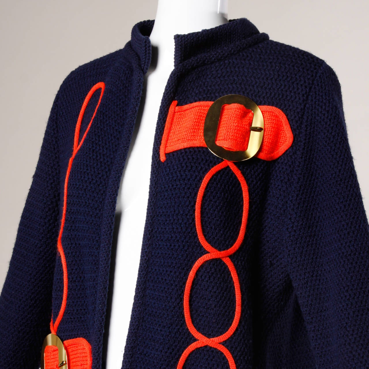 Vintage red and navy wool cardigan sweater with mod buckles and design by Ethel Beverly Hills.

Details:

Unlined
No Closure
Marked Size: Not Marked
Estimated Size: Medium
Color: Bright Red/ Navy/ Gold Metallic
Fabric: Wool
Label: