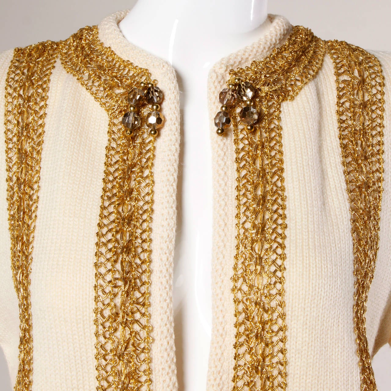 Chunky knit natural wool cardigan sweater with metallic gold trim and bead detail. By Ethel Beverly Hills.

Details:

Unlined
No Closure
Marked Size: Not Marked
Estimated Size: Small
Color: Cream/ Metallic Gold
Fabric: 100% Wool
Label: