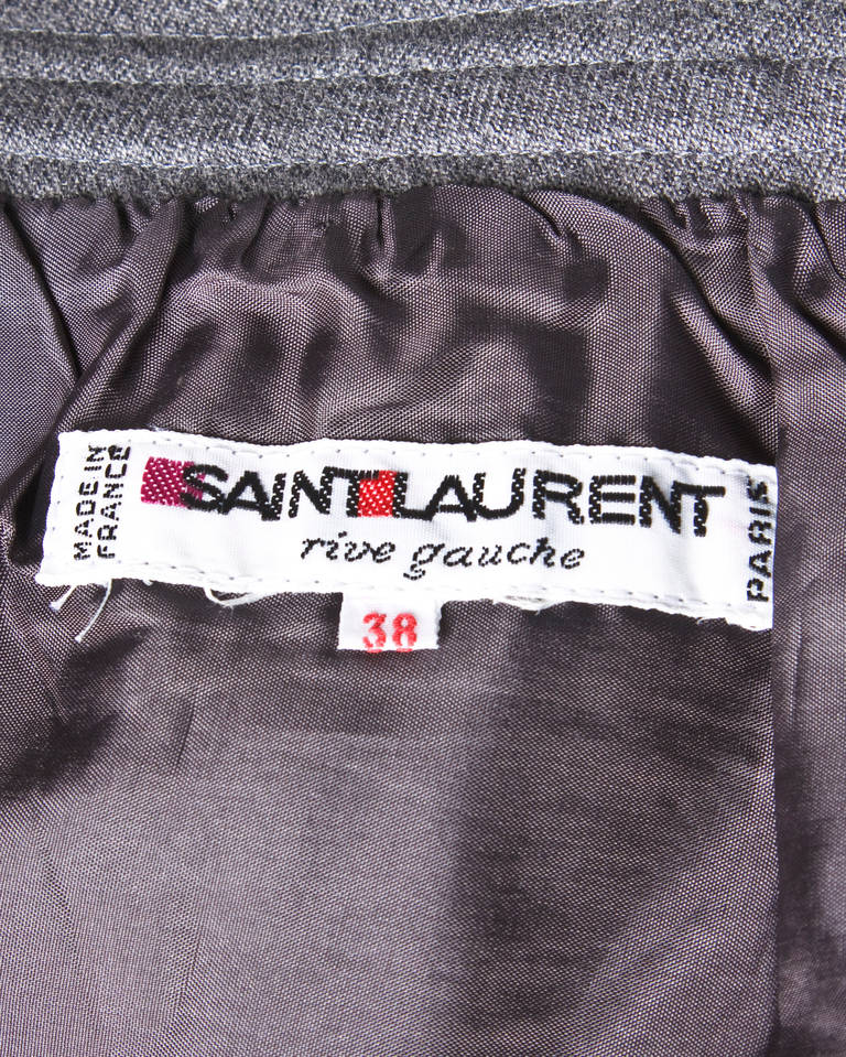 Gorgeous tailored gray wool skirt by Yves Saint Laurent.

Details:

Fully Lined
Side Metal Zip and Hook Closure
Marked Size: 38
Estimated Size: Small
Color: Gray
Fabric: Wool
Label: Yves Saint Laurent Rive Gauche

Measurements:

Waist: