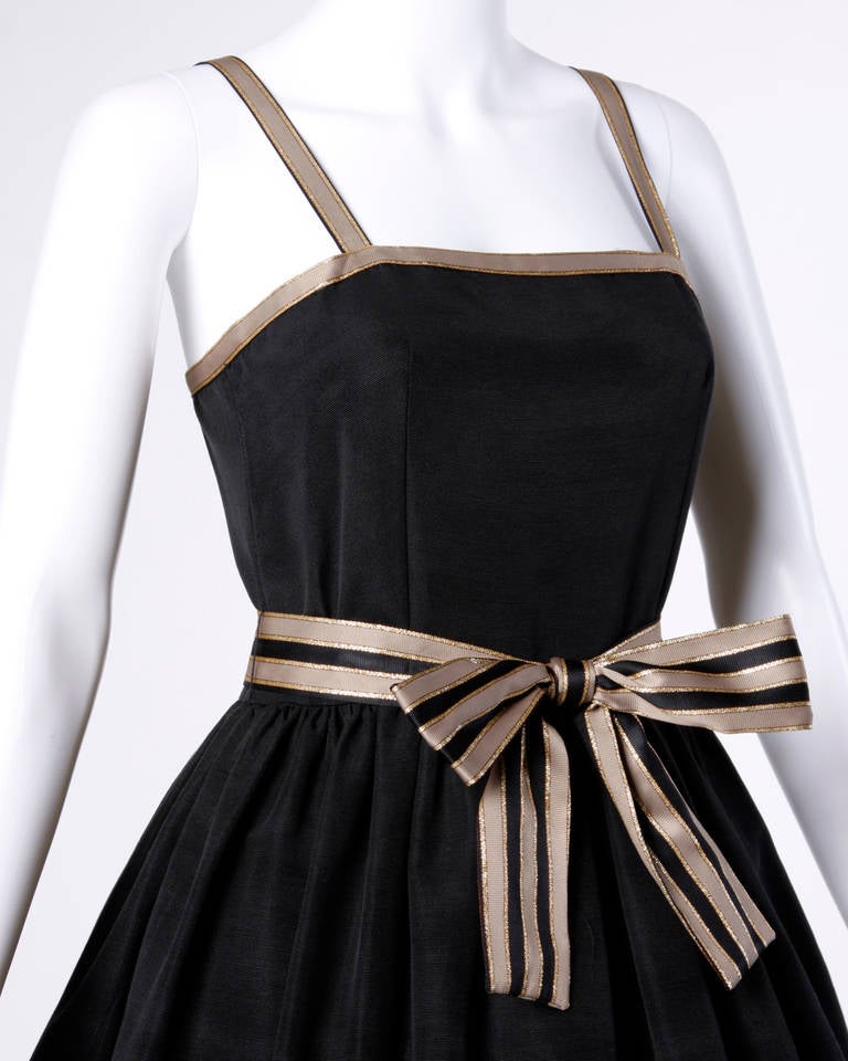 Lillie Rubin party dress in black and tan striped ribbon sash and trim.

Details:

Partially Lined
Side Pockets
Matching Sash Belt
Back Zip and Hook Closure
Marked Size: 6
Color: Black/ Gold/ Taupe
Label: Lillie