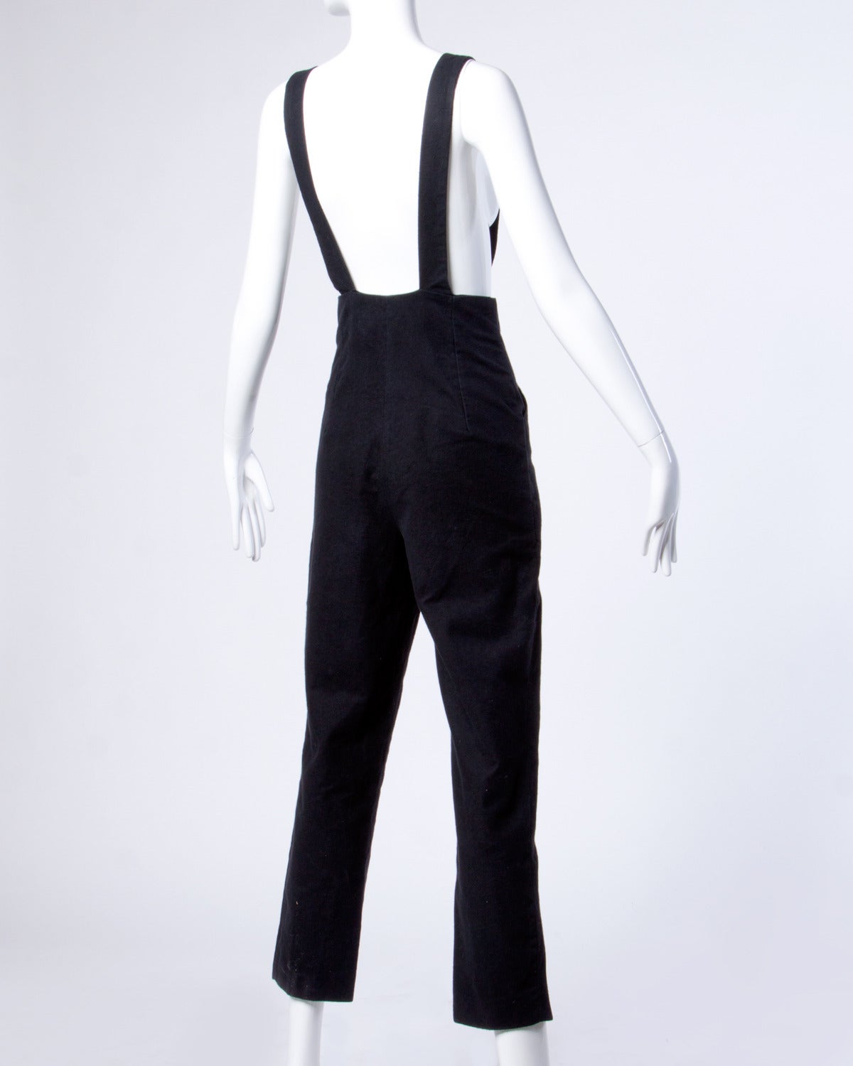 Incredible black overall jumpsuit by Marina Sitbon for Kamosho. Rare iconic 90s label is hard to find. Versace-inspired heavy goldtone and black buttons and hardware. High waist and adjustable straps.

Details:

Unlined
Side Pockets
Front