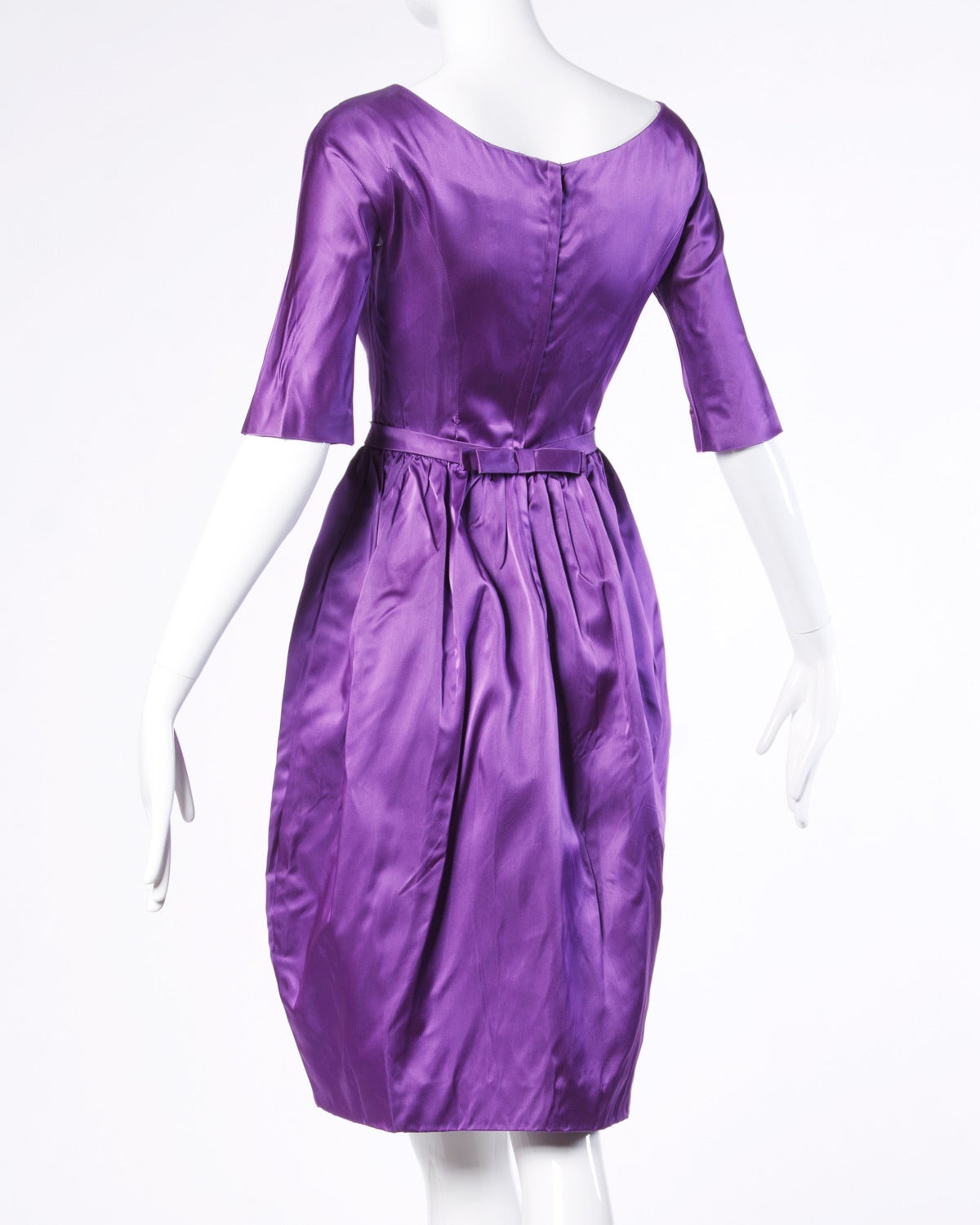 Vintage purple satin cocktail dress with 3/4 length sleeves and a tiny nipped waist.

Details:

Estimated Size: XS
Partially Lined
Back Metal Zip Snap and Hook Closure
Color: Purple
Fabric: Satin

Measurements:

Bust: 32
