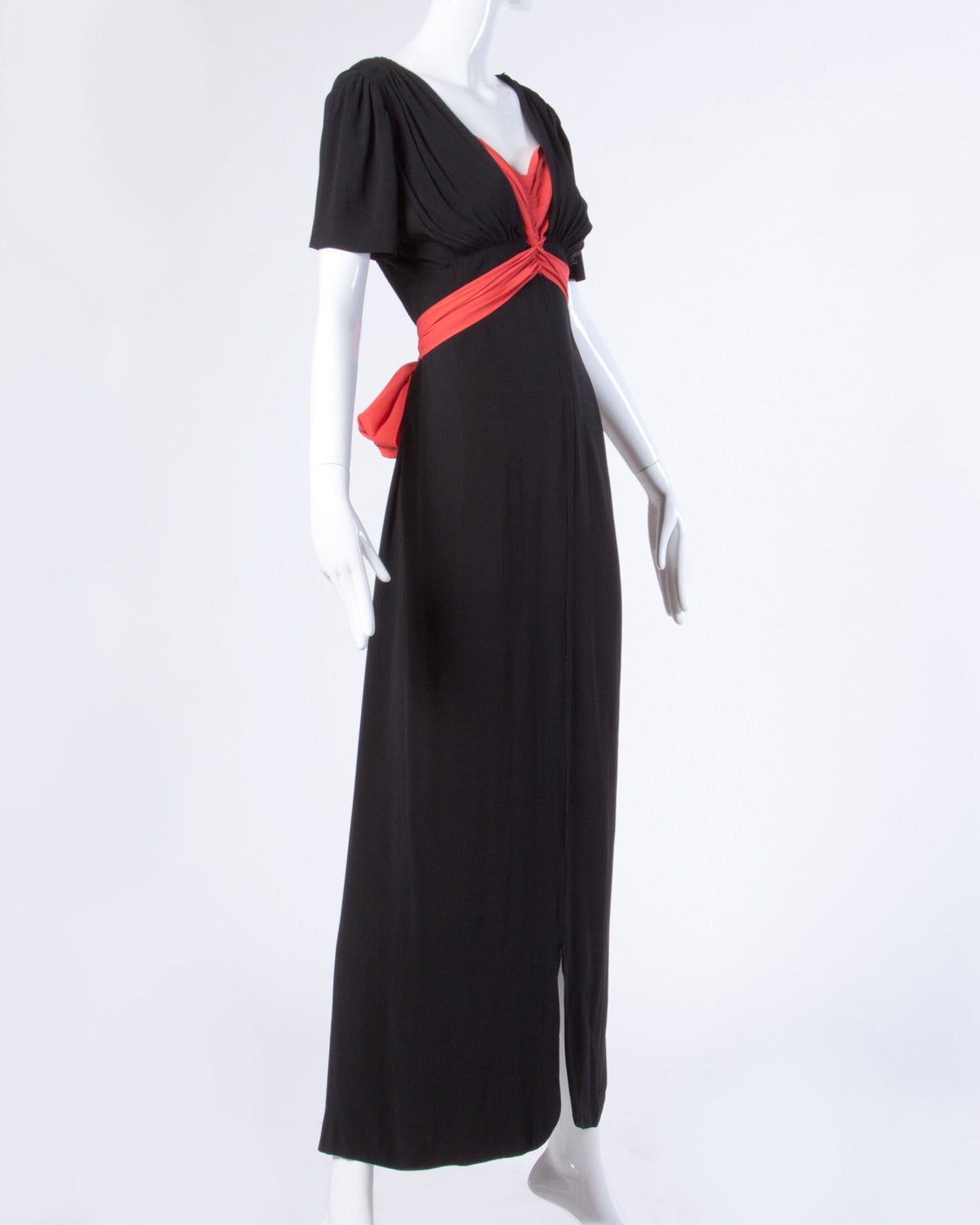Gorgeous vintage black and coral gown with an empire waist and short sleeves. Classy and elegant.

Details:

Partially Lined
Side Metal Zip and Snap Closure
Estimated Size: XS-M
Marked Size: Not Marked
Color: Coral/ Black
Fabric: