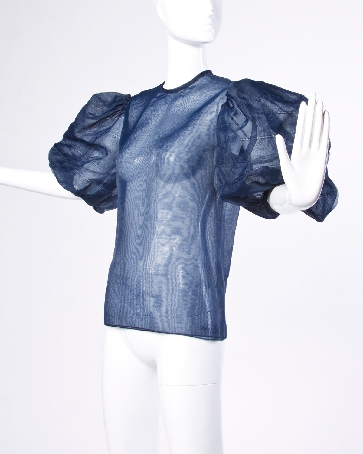 Dramatic navy blue organza silk top with puff sleeves by William Pearson.

Details:

Unlined
Back Button Closure
Marked Size: 10
Color: Navy Blue
Fabric: Organza
Label: William Pearson

Measurements:

Bust: Up To 38