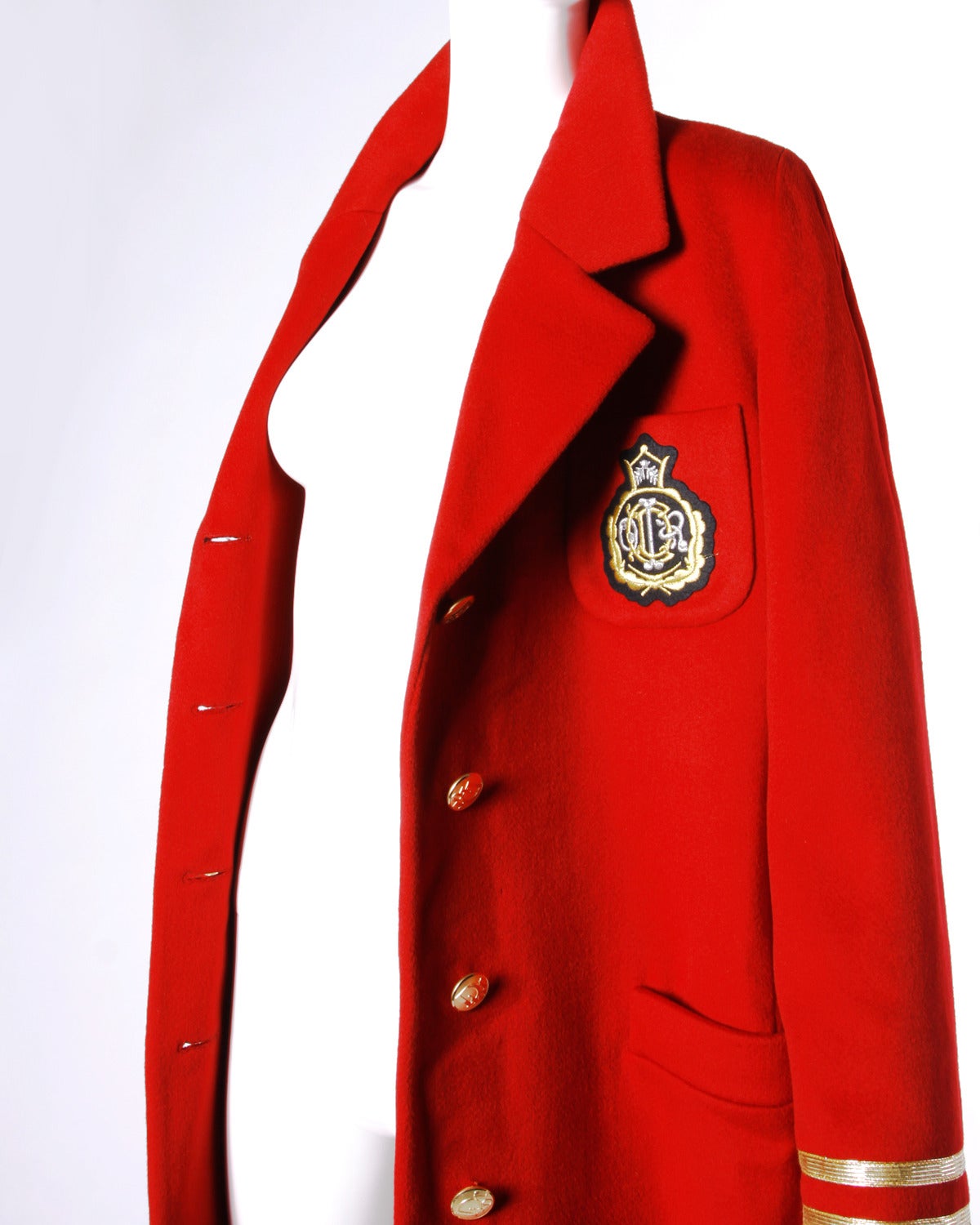 Heavy vintage military-inspired coat by Christian Dior. Gold striped sleeves and military crest on the front breast.

Details:

Fully Lined
Shoulder Pads Sewn Into Lining
Front Button Closure
Color: Red
Fabric: Wool
Label: Christian