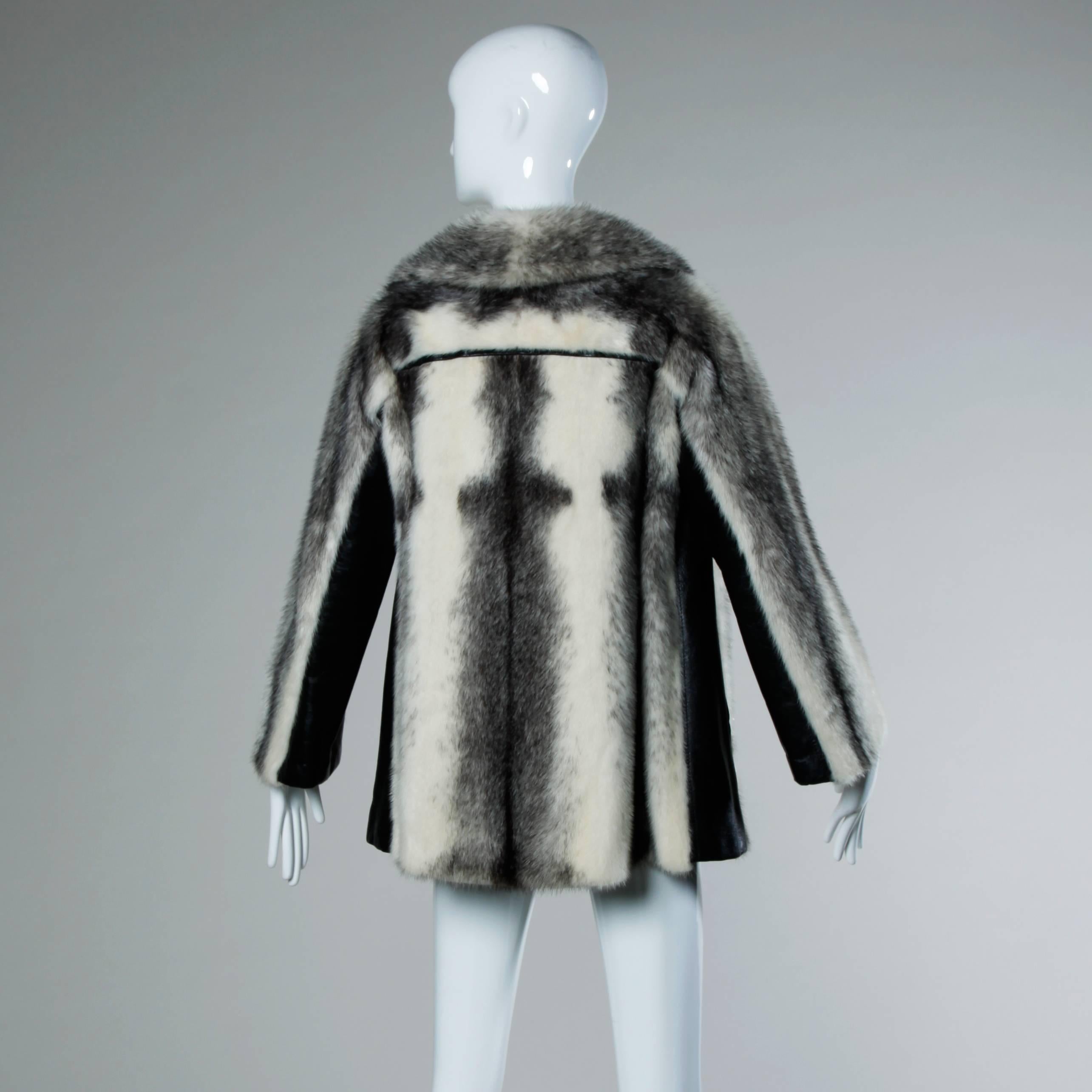 Vintage black and white cross mink fur coat or jacket with leather side panels and buttons. Fur is in excellent condition with no oxidation. Pelts are soft and supple.

Details:

Fully Lined
Front Pockets/ Right Hidden Pocket 
Front Hook