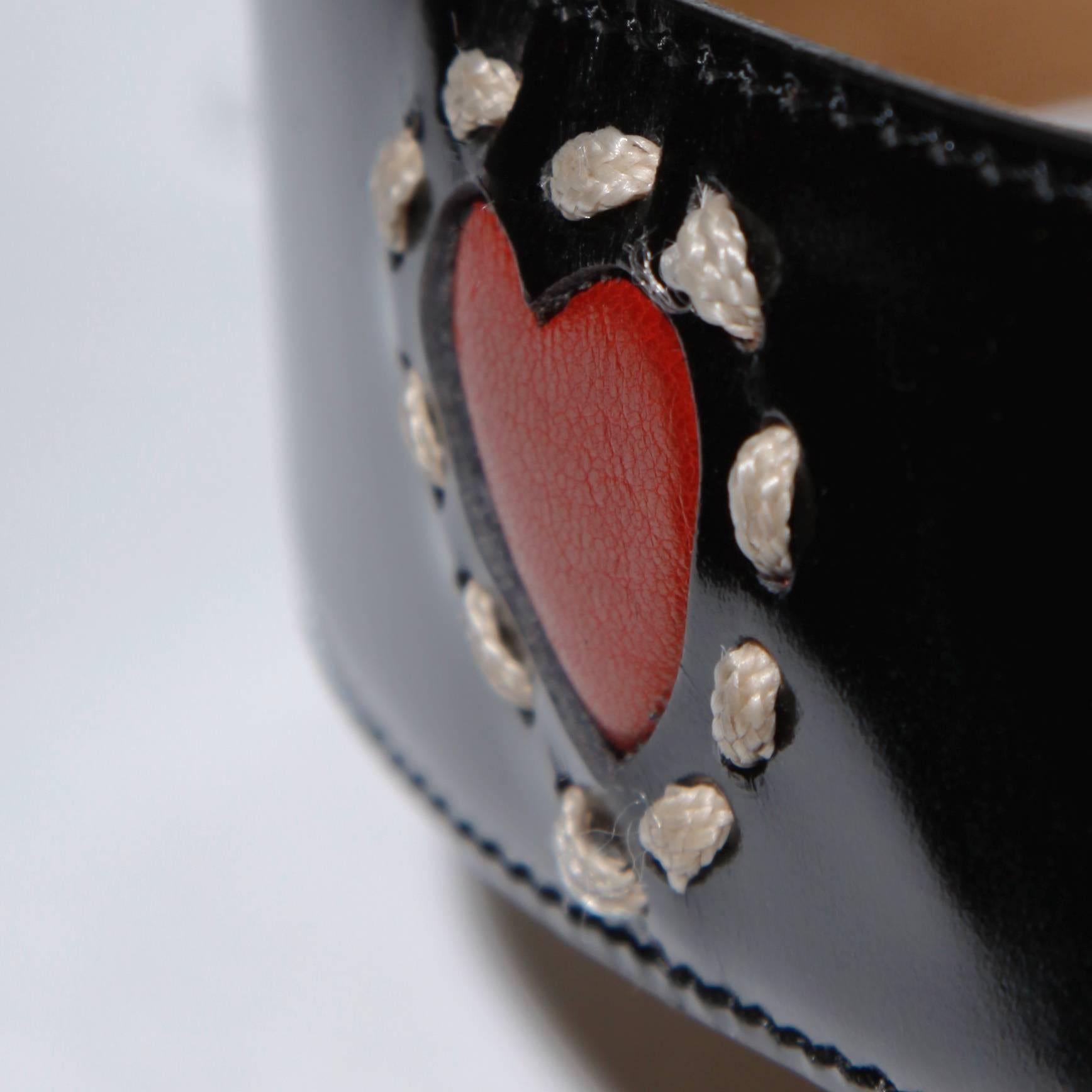 Moschino by Redwall vintage black leather belt with red hearts and a big gold tone heart buckle. Decorative stitching. Estimated size large.

Details:

Front Buckle Closure 
Color: Gold/ Black/ Red
Fabric: Leather/ Metal 
Label: