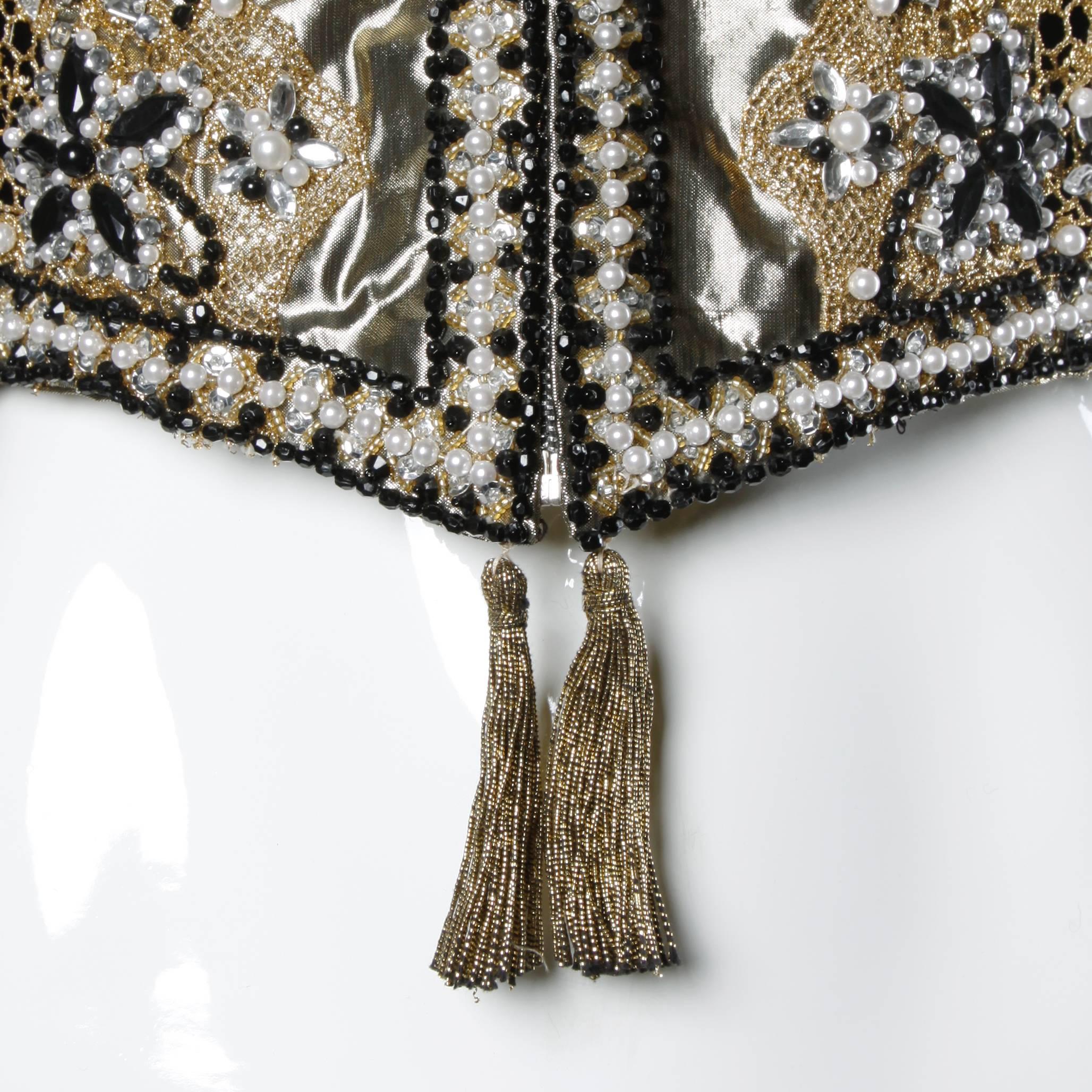 Matador-inspired rock star trophy jacket in metallic gold and black. Heavily embellished design with rhinestones and beadwork. Gold tassel detail at the bottom of the zipper.

Details:

Fully Lined
Shoulder Pads Sewn Into Lining
Front Metal