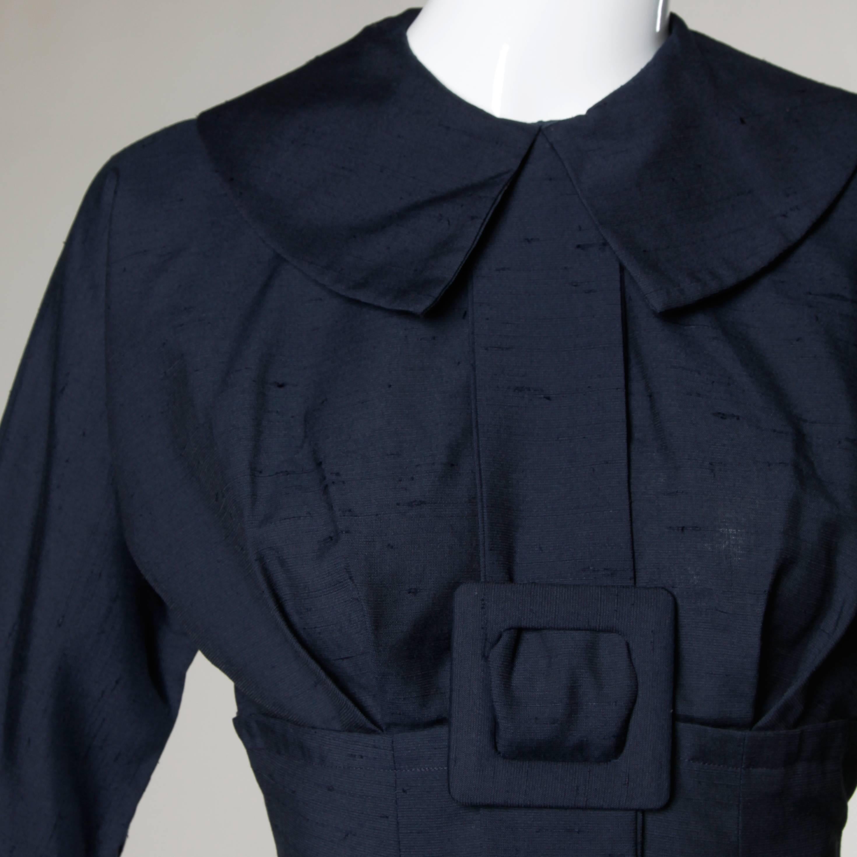 Va-voom! Vintage navy blue wiggle dress with a buckle detail and hourglass silhouette. Cropped sleeves and pilgrim collar.

Details:

Unlined
Back Metal Zip and Hook Closure 
Marked Size: Not Marked
Estimated Size: Small
Color: Navy